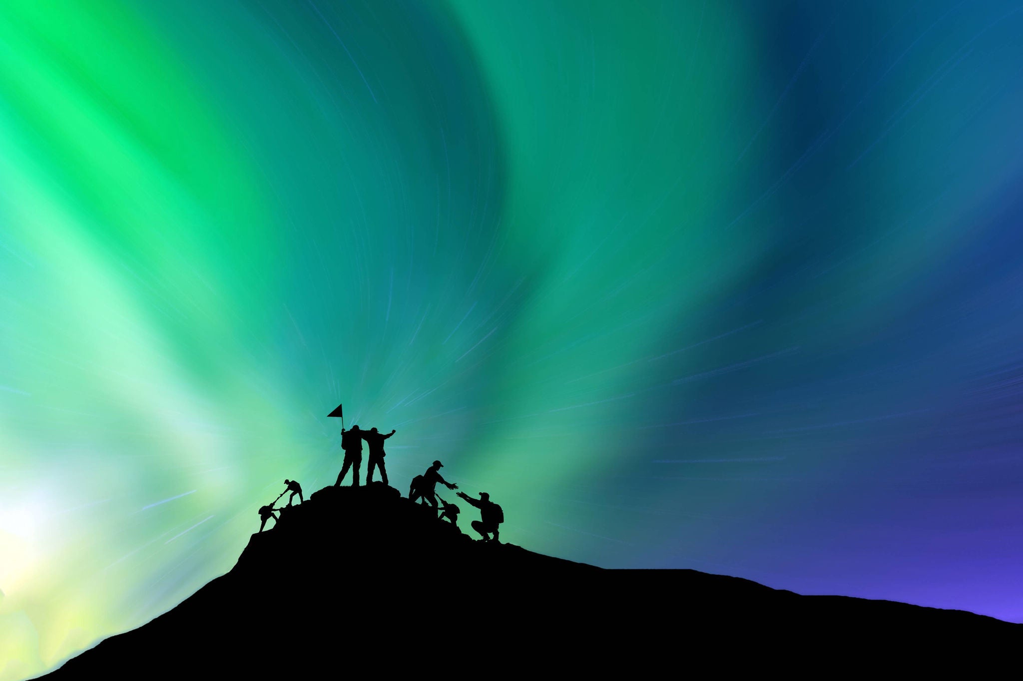 People climbing on a mountain top and waving the flag