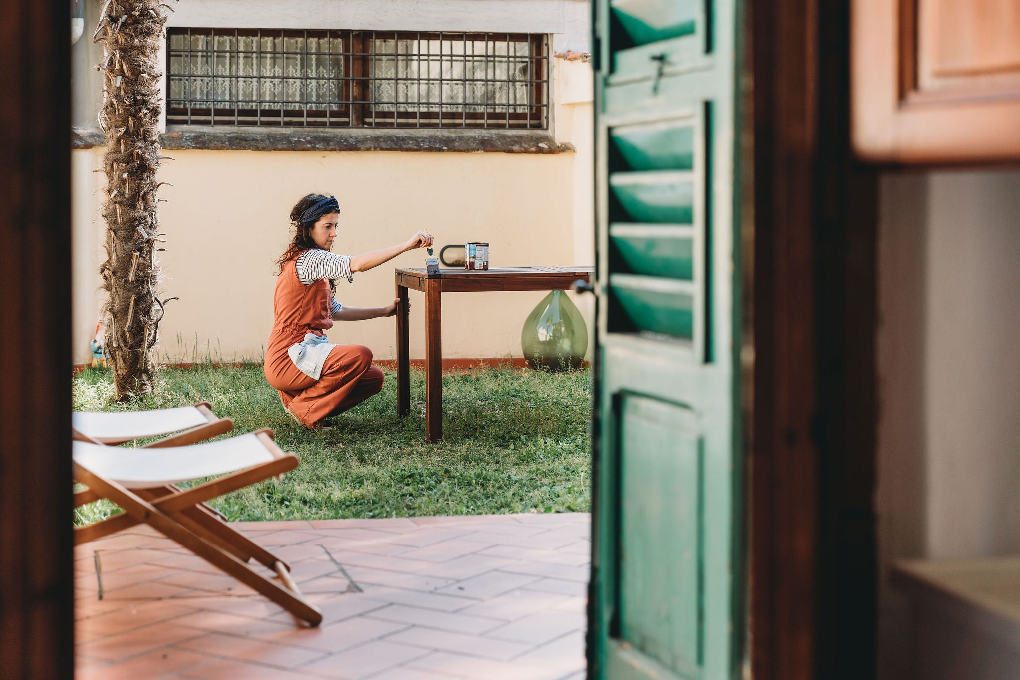 Portrait young woman painting a wooden table