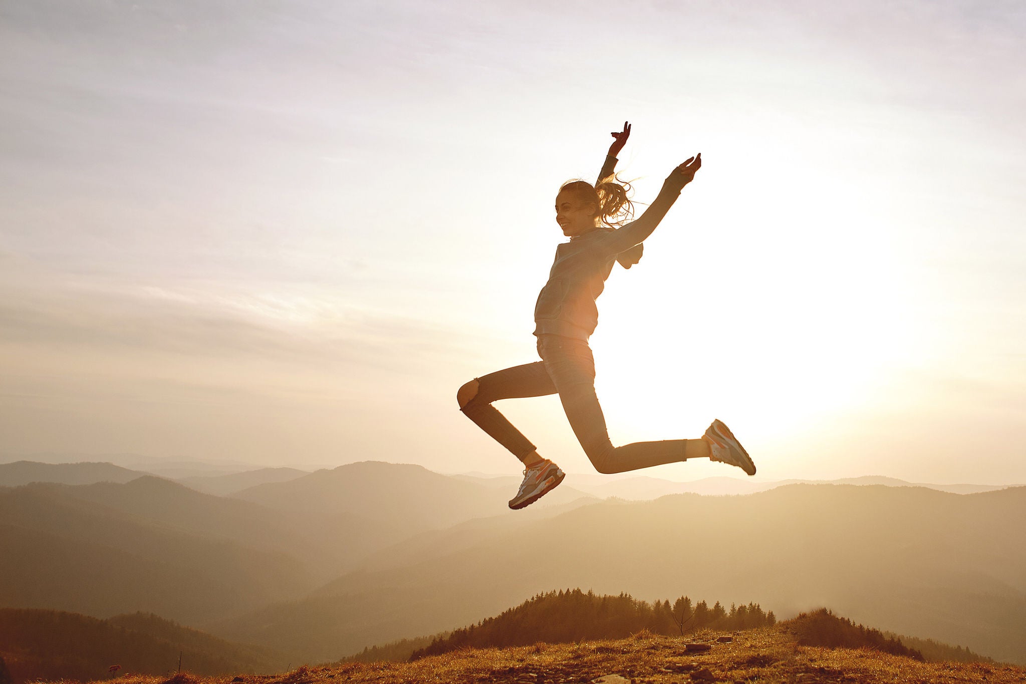 Woman leaping on mountain