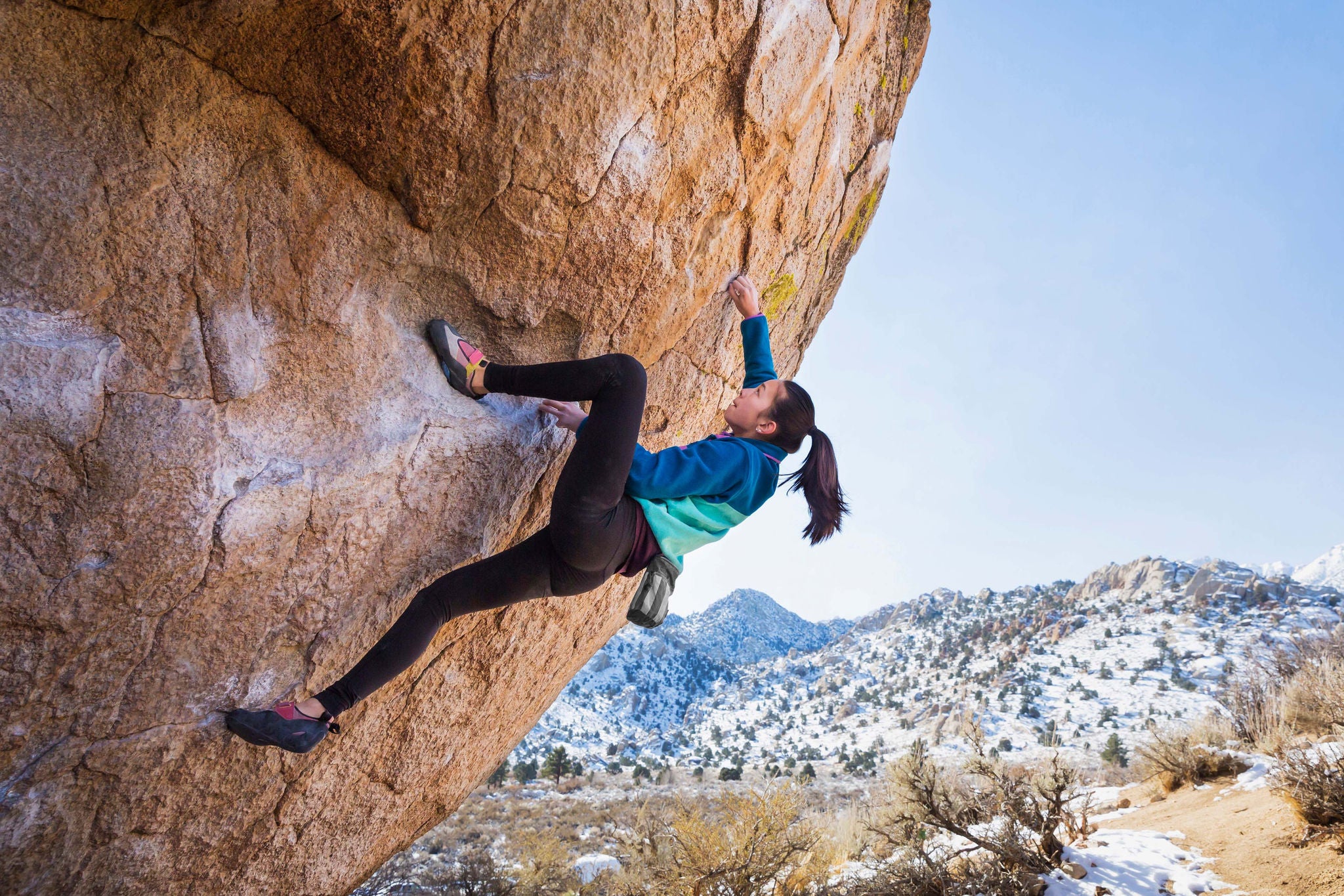 Girl climbing rock in the mountains