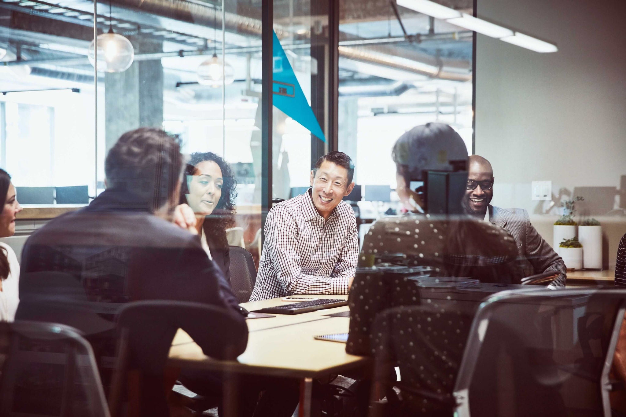 EY - Co-workers sitting around conference table