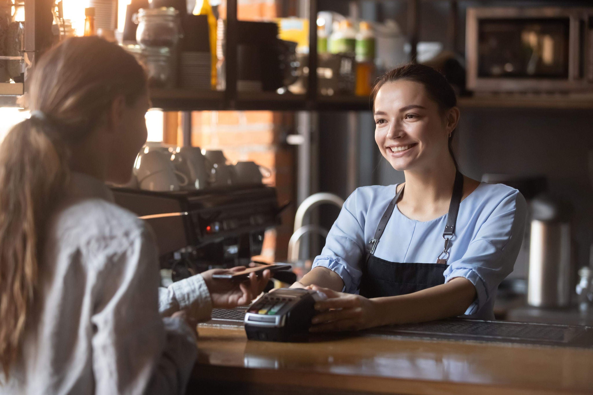 Customer holding phone near NFC terminal makes contactless mobile payment