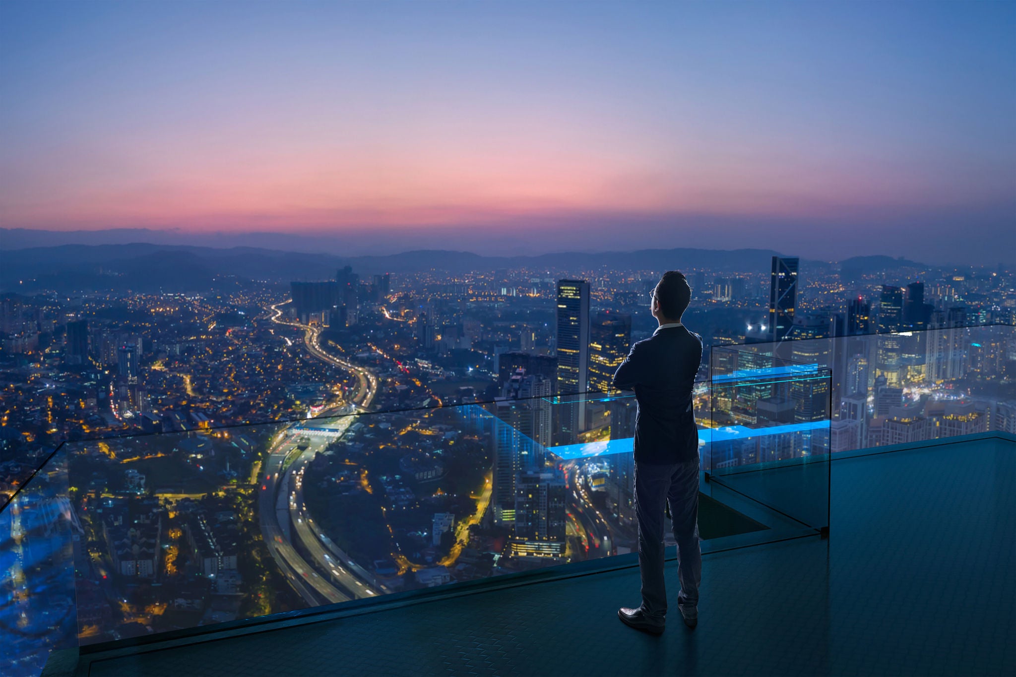 businessman standing on open roof top balcony