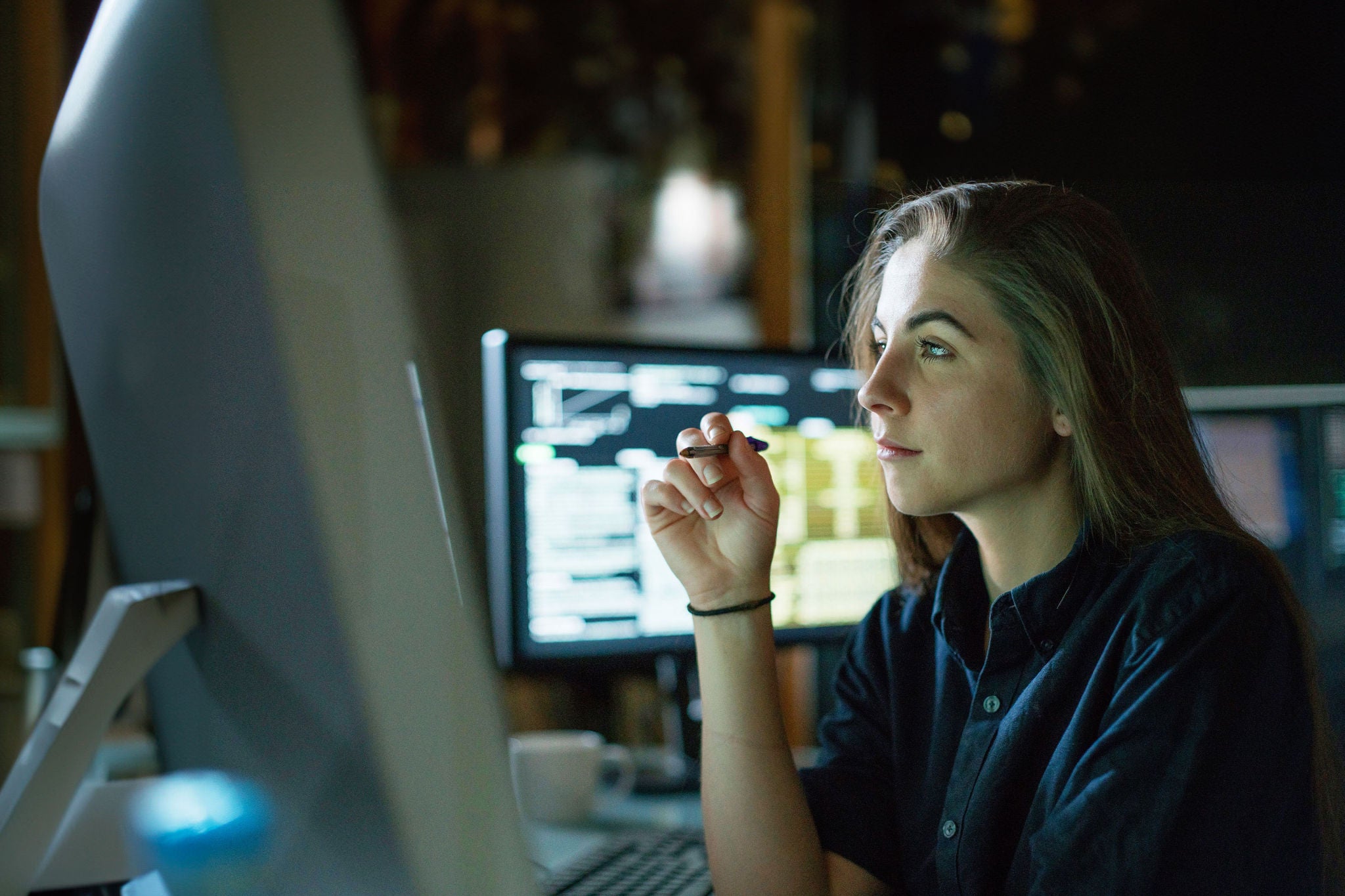 Woman monitors dark office