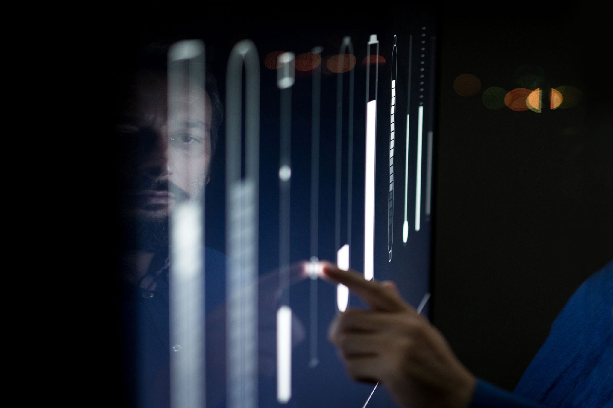 Man operating in control room moving sliders on screen 