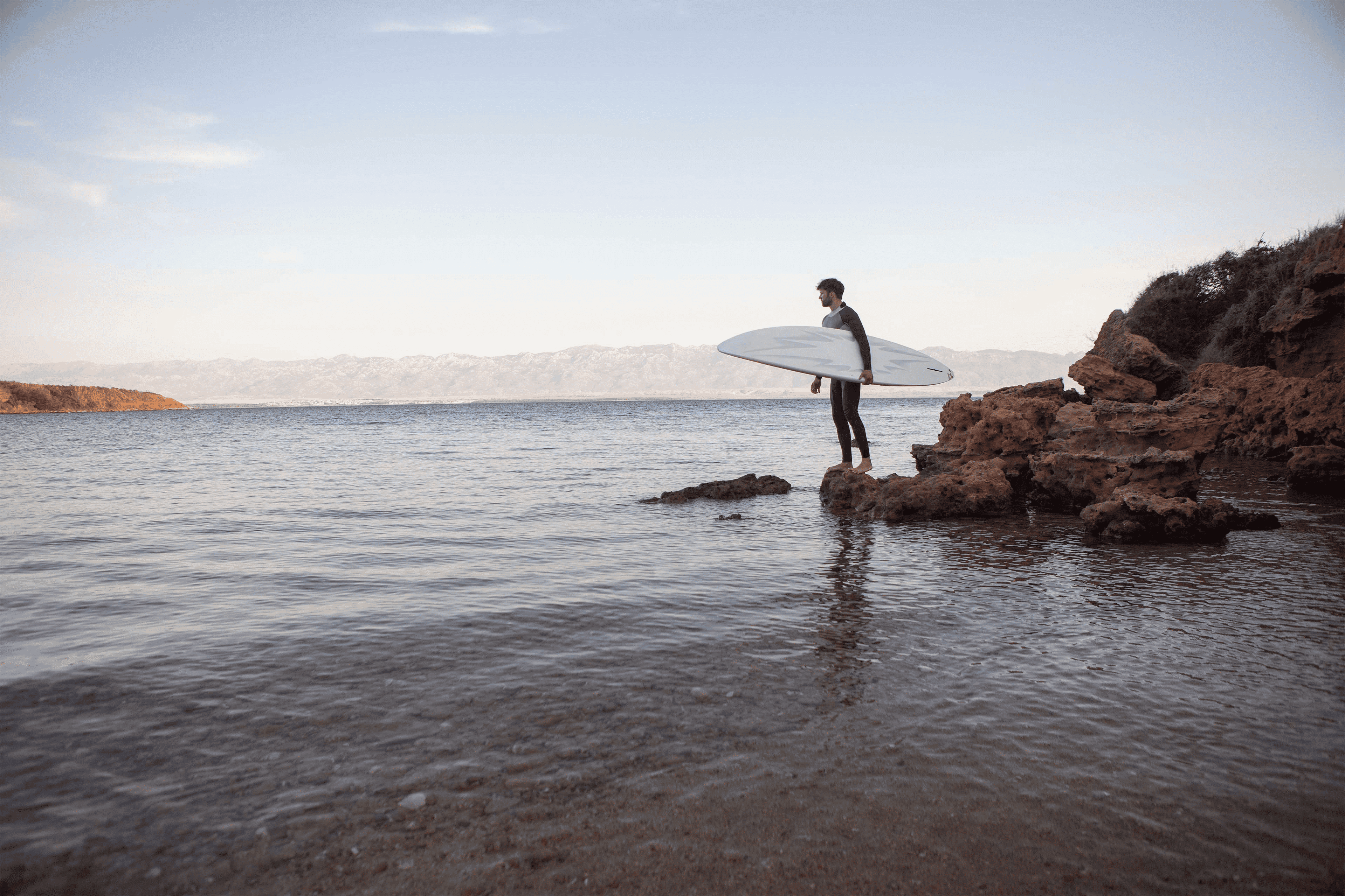 Person Holding Surfing Board And Facing The Sea