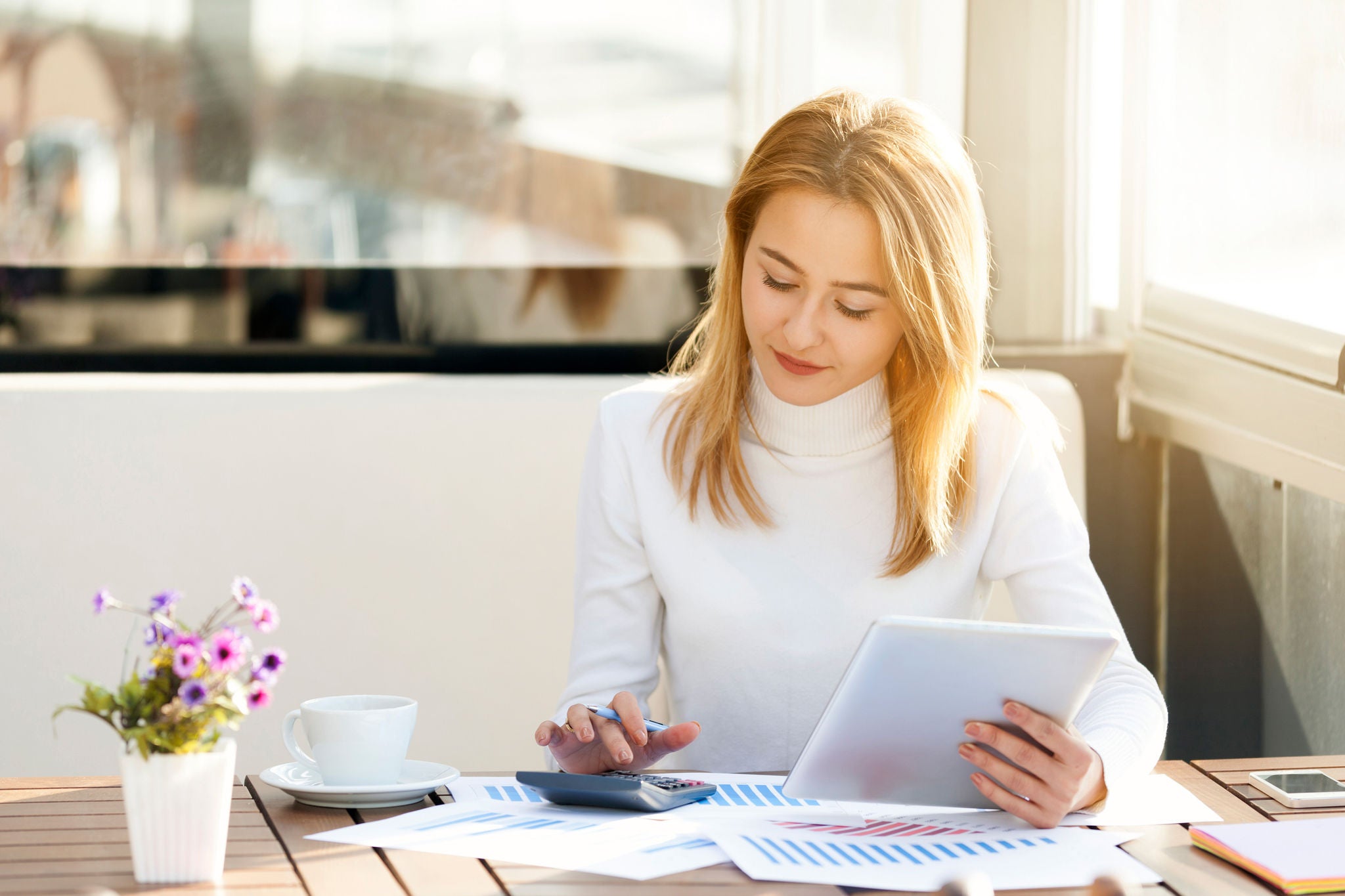 ey woman calculating on a desk