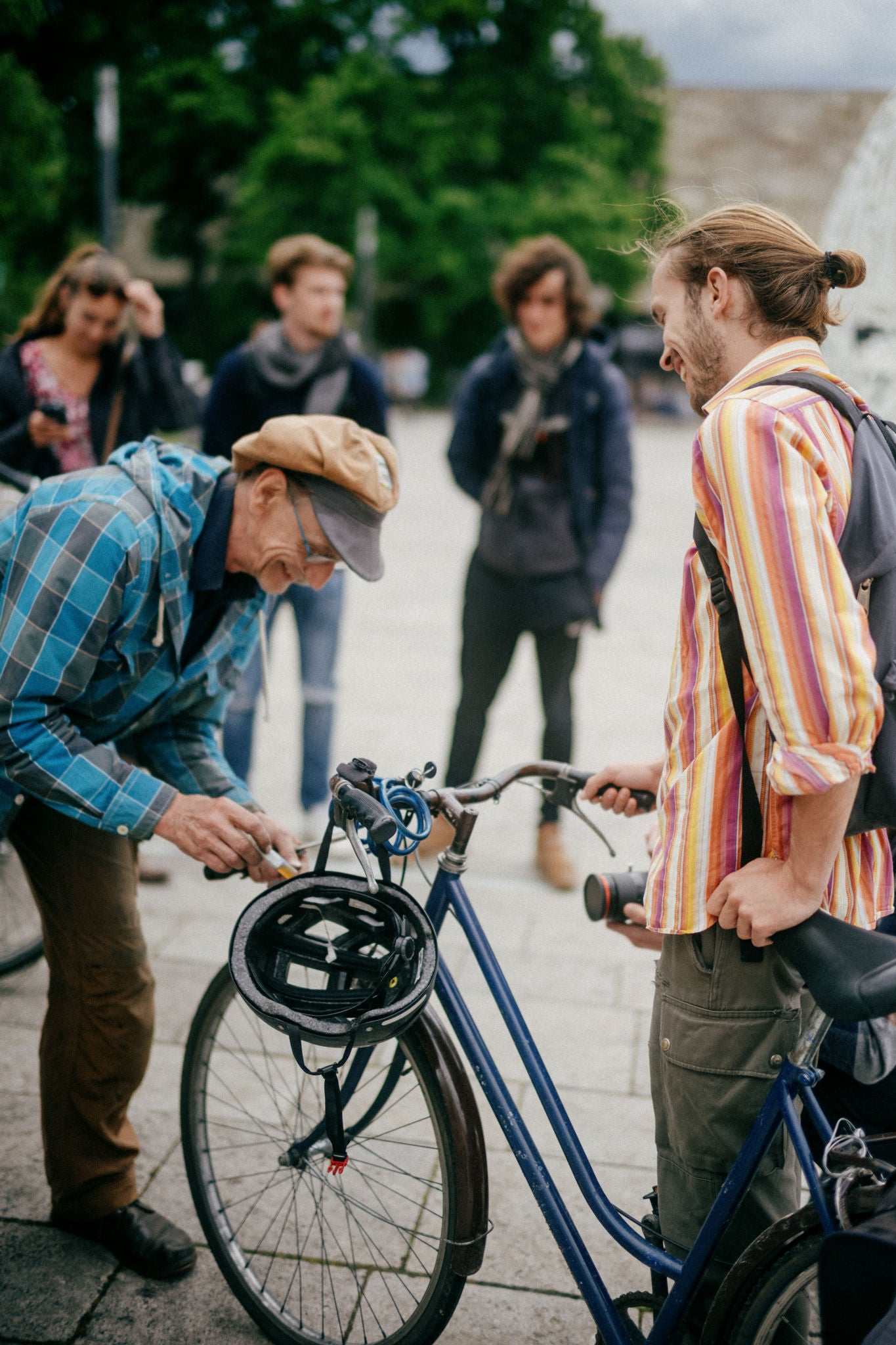 Old man setting up front wheel to bicycle