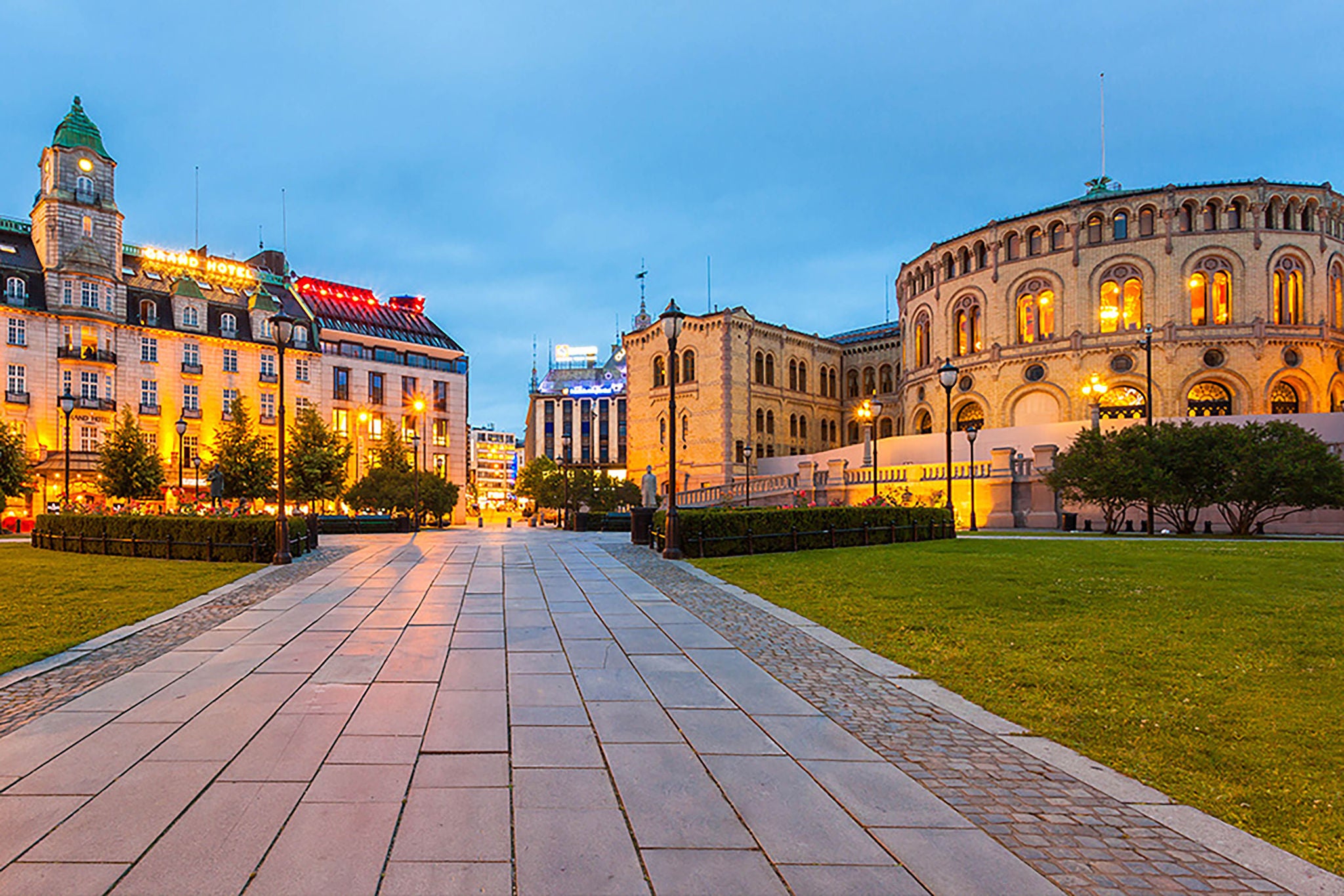 Bilde av Stortinget i Oslo med Grand Hotel og Karl Johan i bakgrunn.