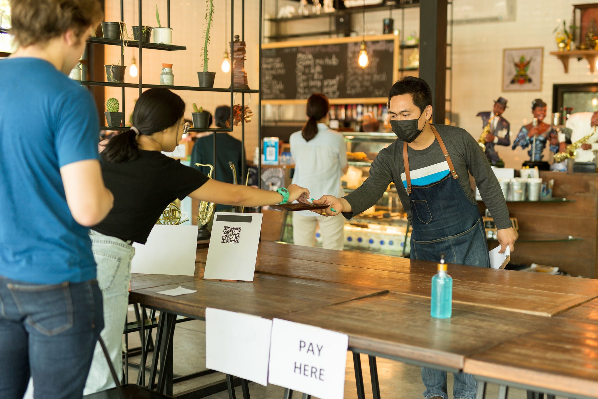 Social distance conceptual small business waiter serving customer in cafe