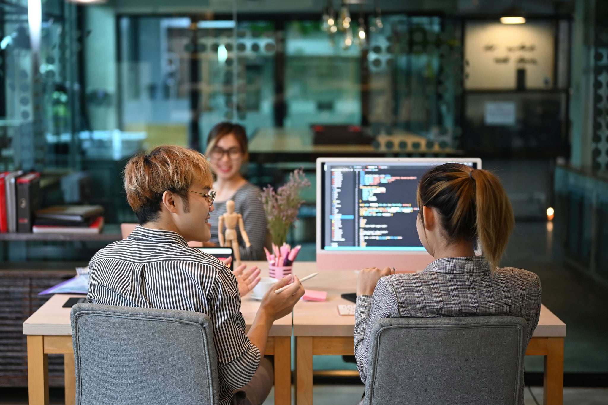 Team of young professionals brainstorming and working in software development office.