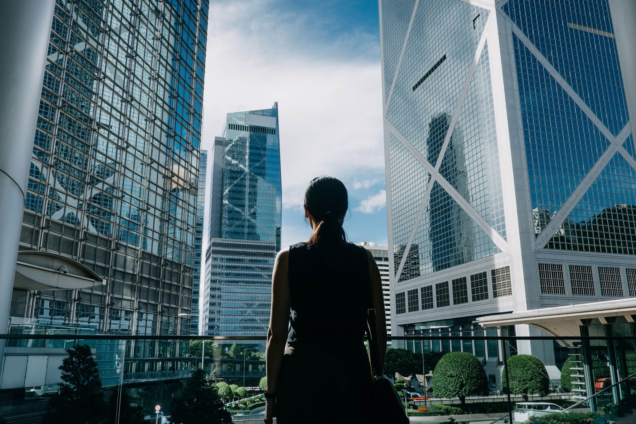 Businesswoman standing against financial district skyscrapers