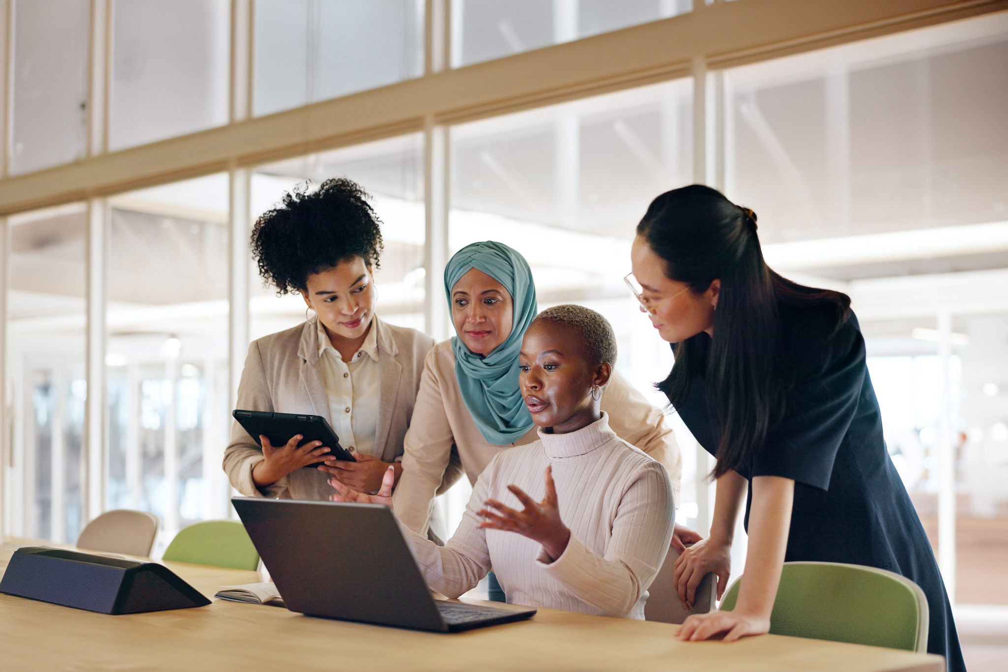 Diversity, corporate and women with laptop, talking and planning budget, fintech and system update in modern office. Team, leader and group online reading, finance and.accounting process on computer.