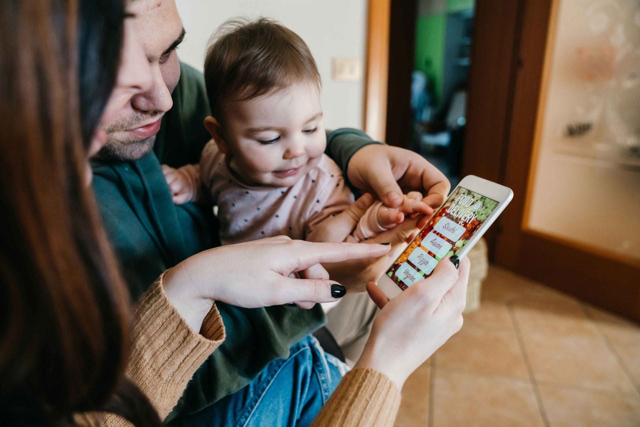 eine Familie beim Online-Einkauf mit einem Mobiltelefon