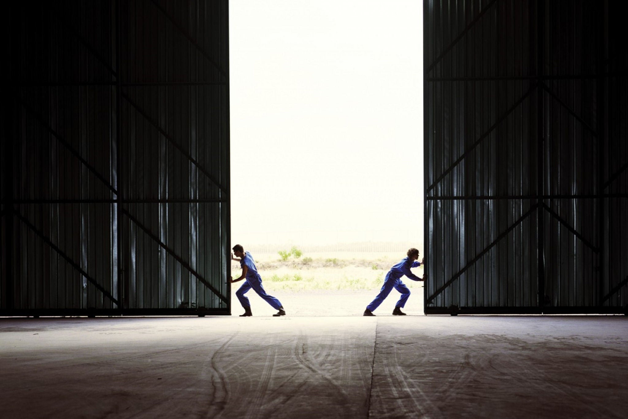 Two men opening the heavy door