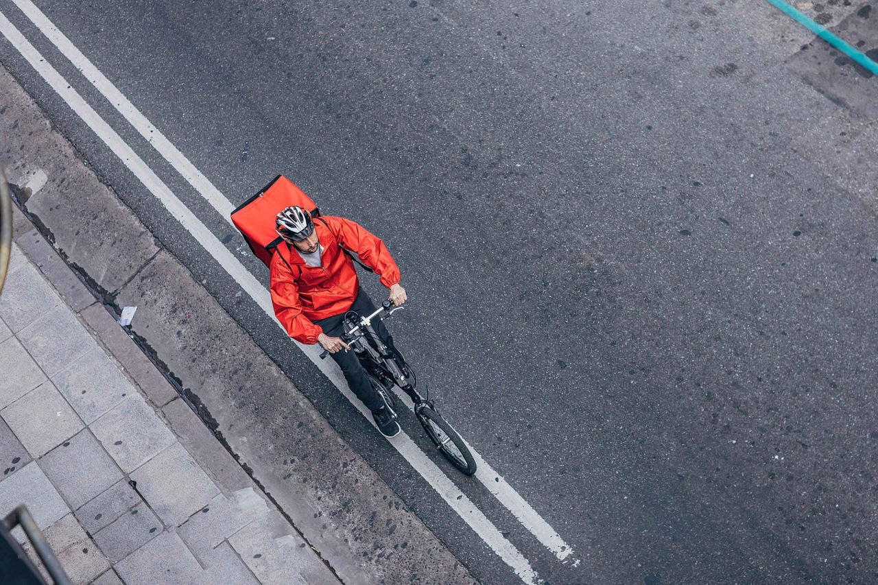 Ein Zusteller, der ein Fahrrad fährt