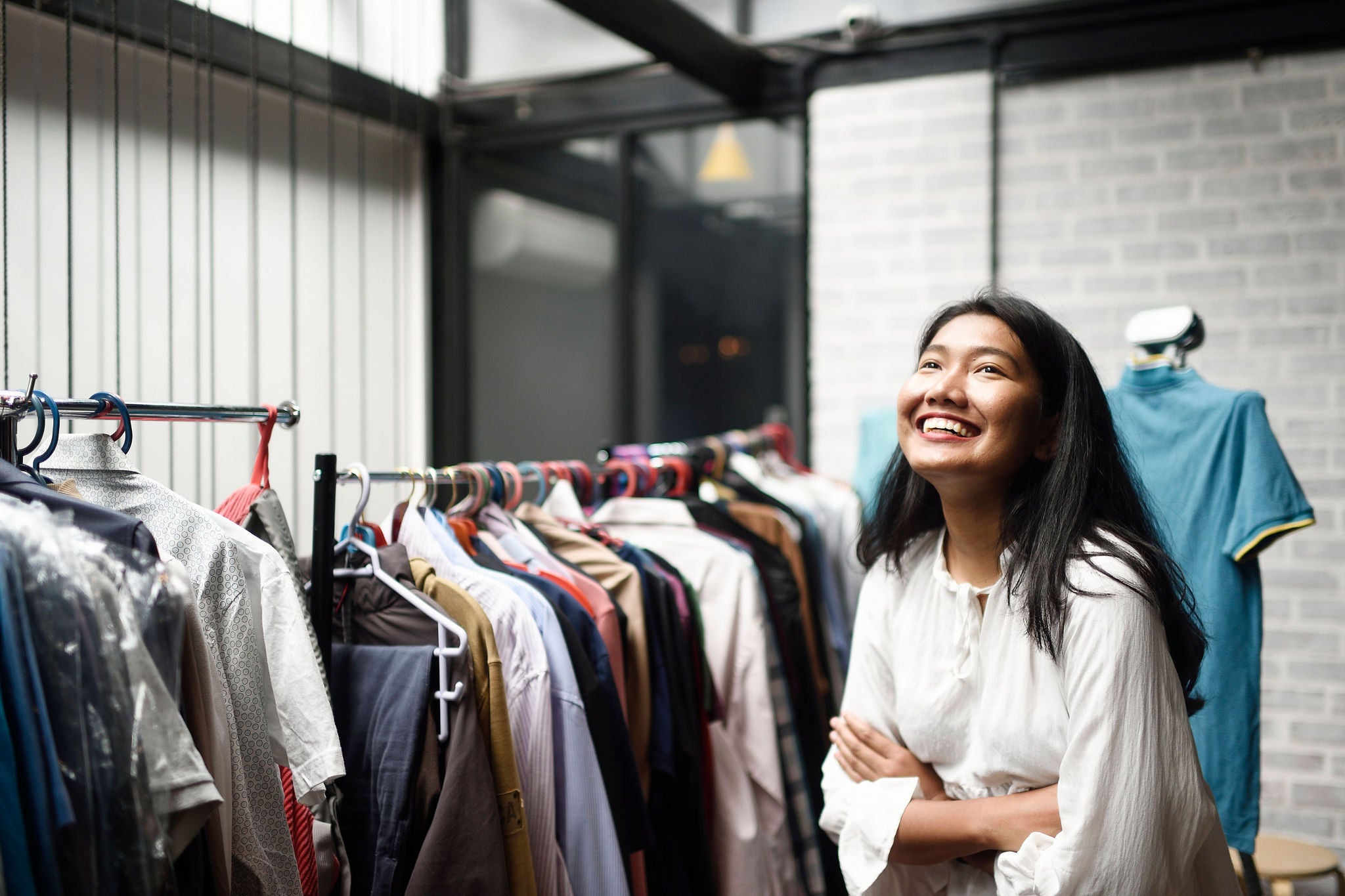 Smiling business woman in front of a clothing rack in a boutique