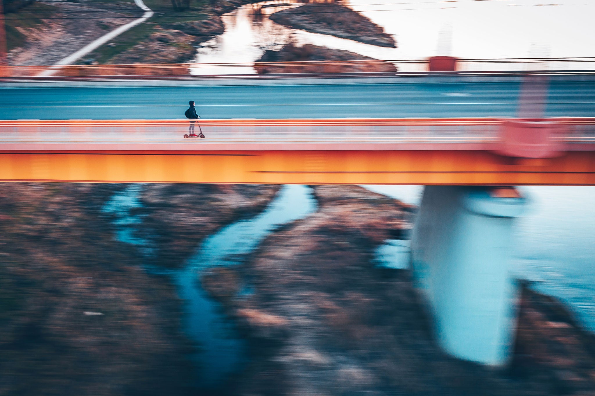 Blurred motion of person riding push scooter