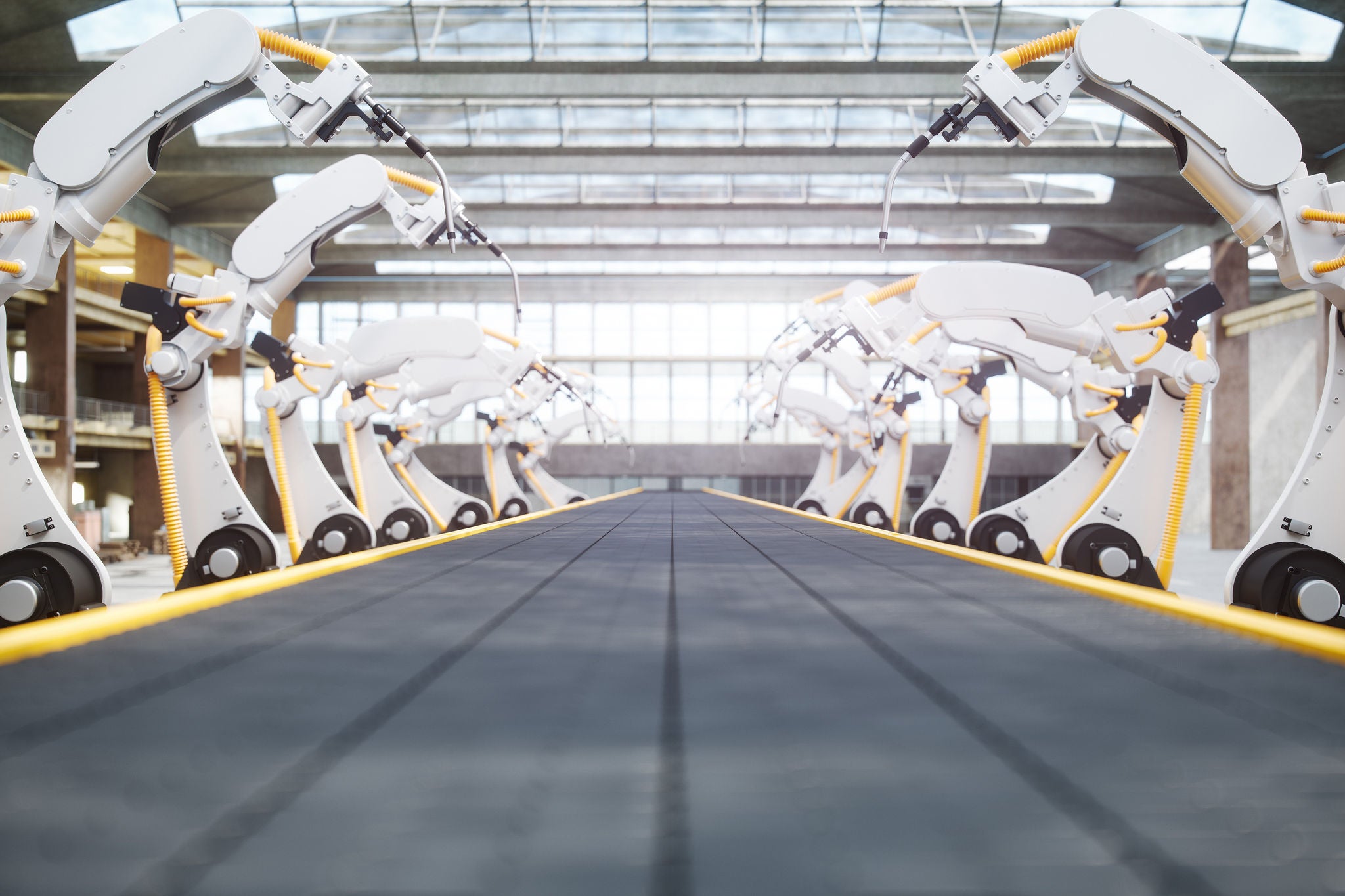 Interior of a modern automated factory with robotic arms and conveyor belt.