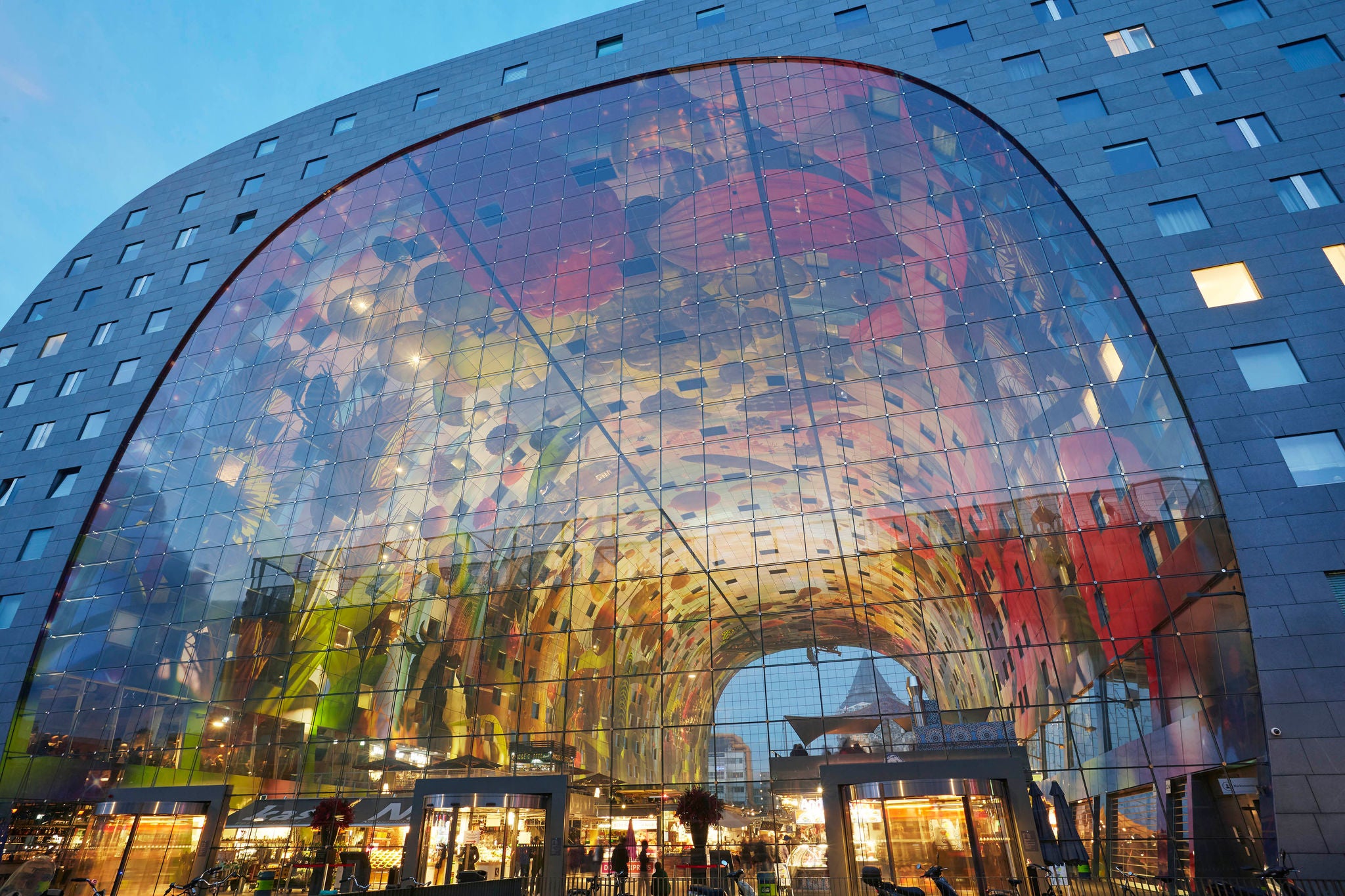 Facade of the 'Markthal' market Hall in Rotterdam illuminated at dusk. Opened in 2014 it provides cover for 100 stalls and was designed by MVRDV architects