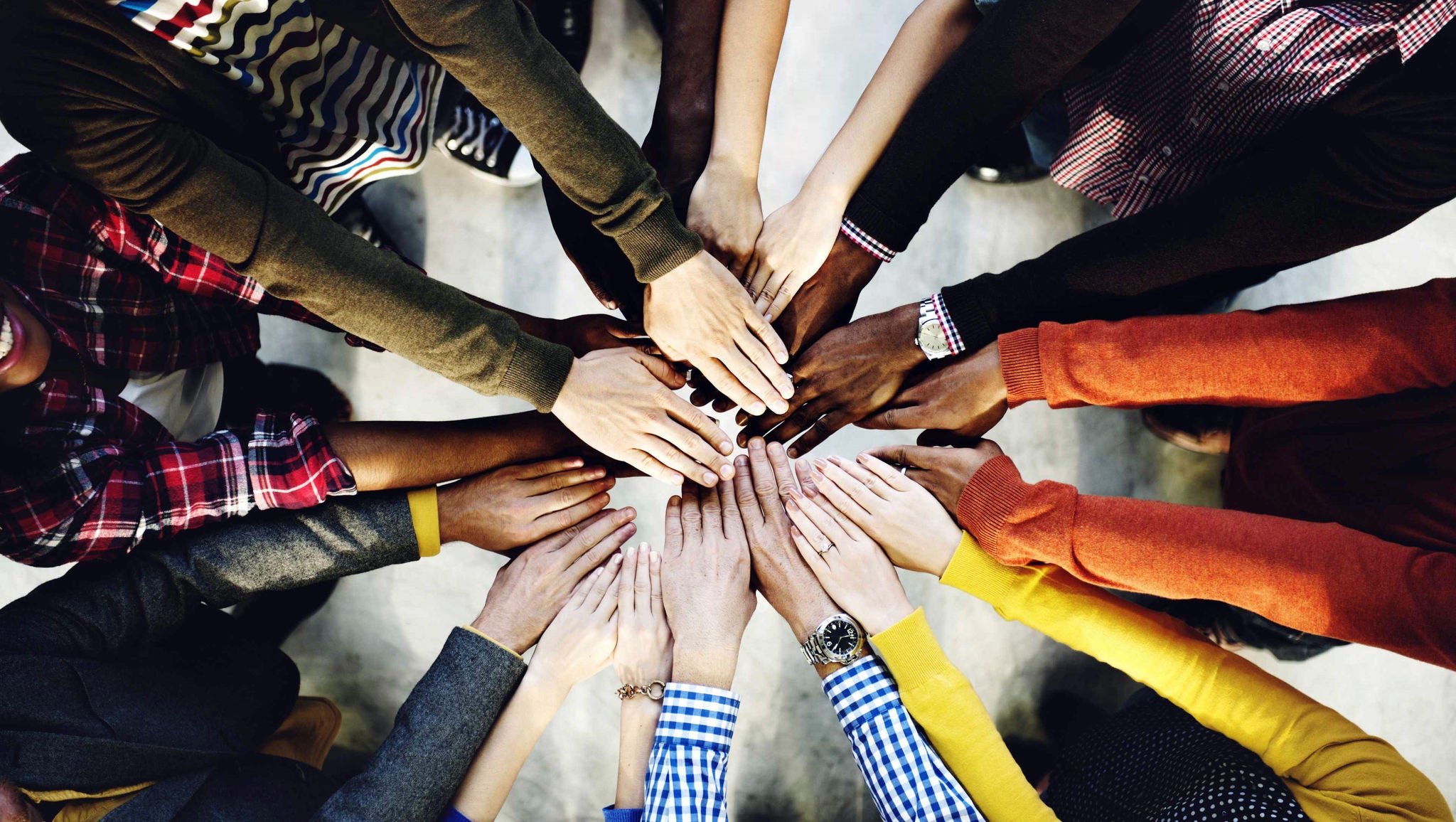 Close up image of many hands forming a circle