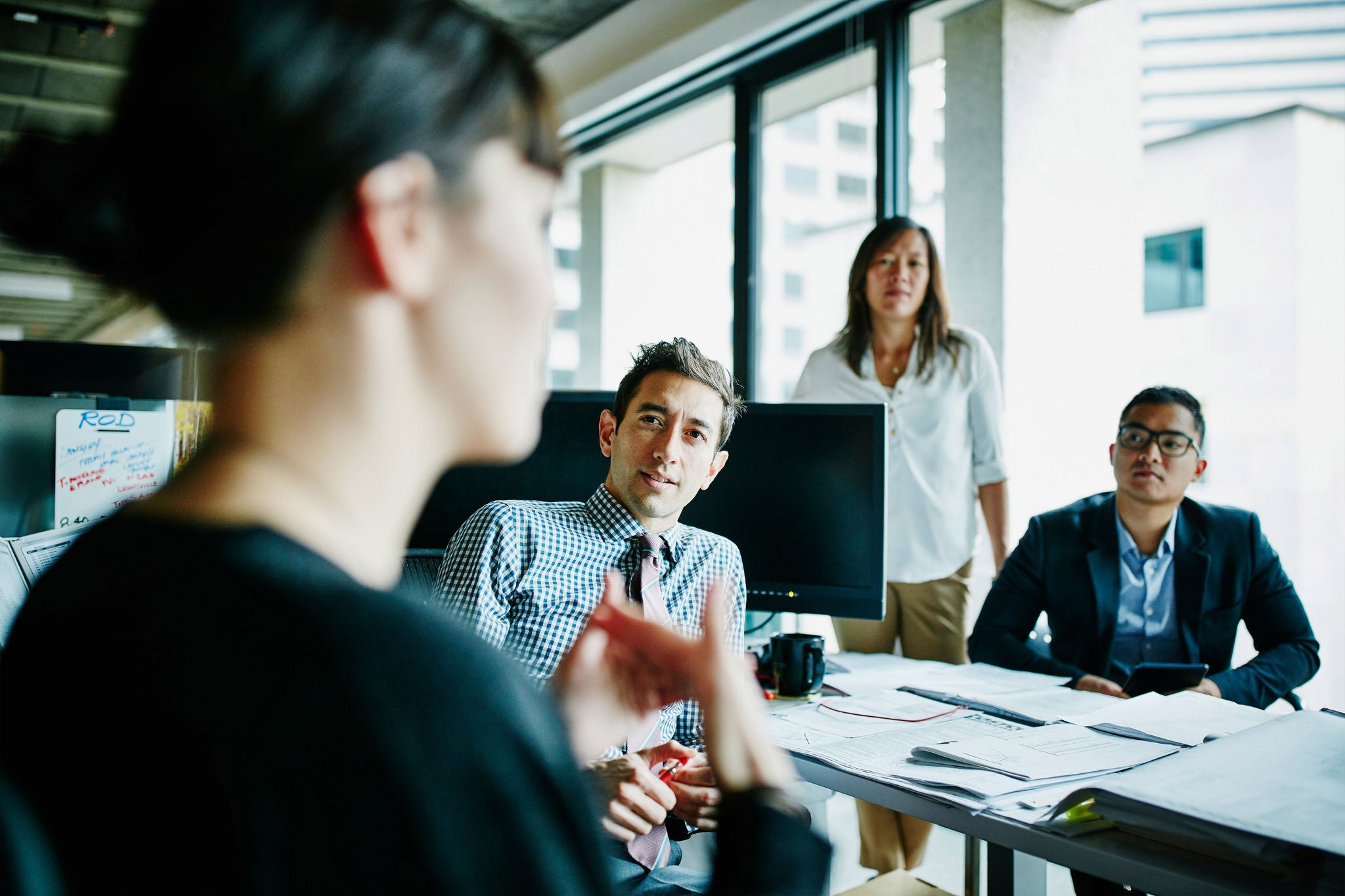 Businesswoman leading team meeting with coworkers in office