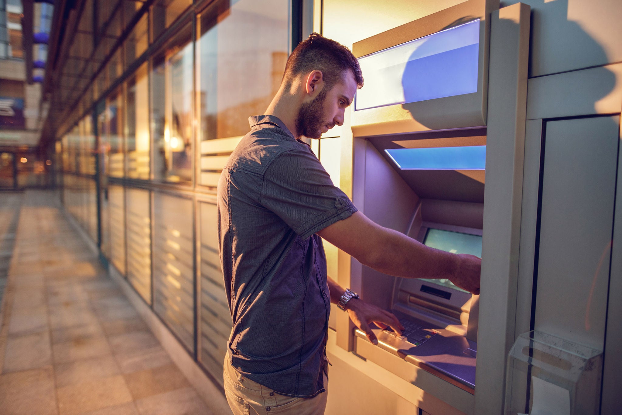 Businessman withdrawing cash from a bank's ATM.