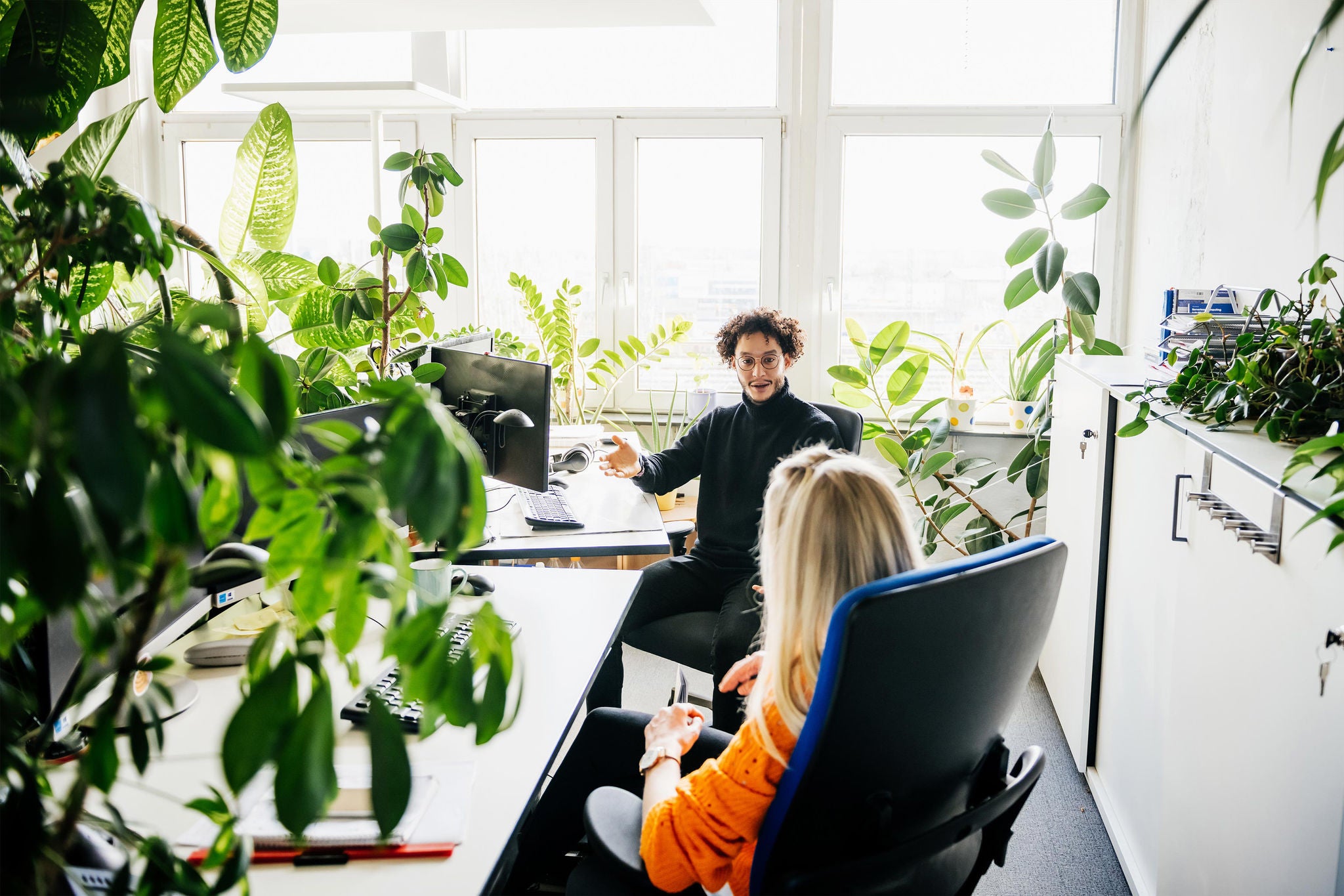 kollegen besprechen die arbeit an ihren schreibtischen