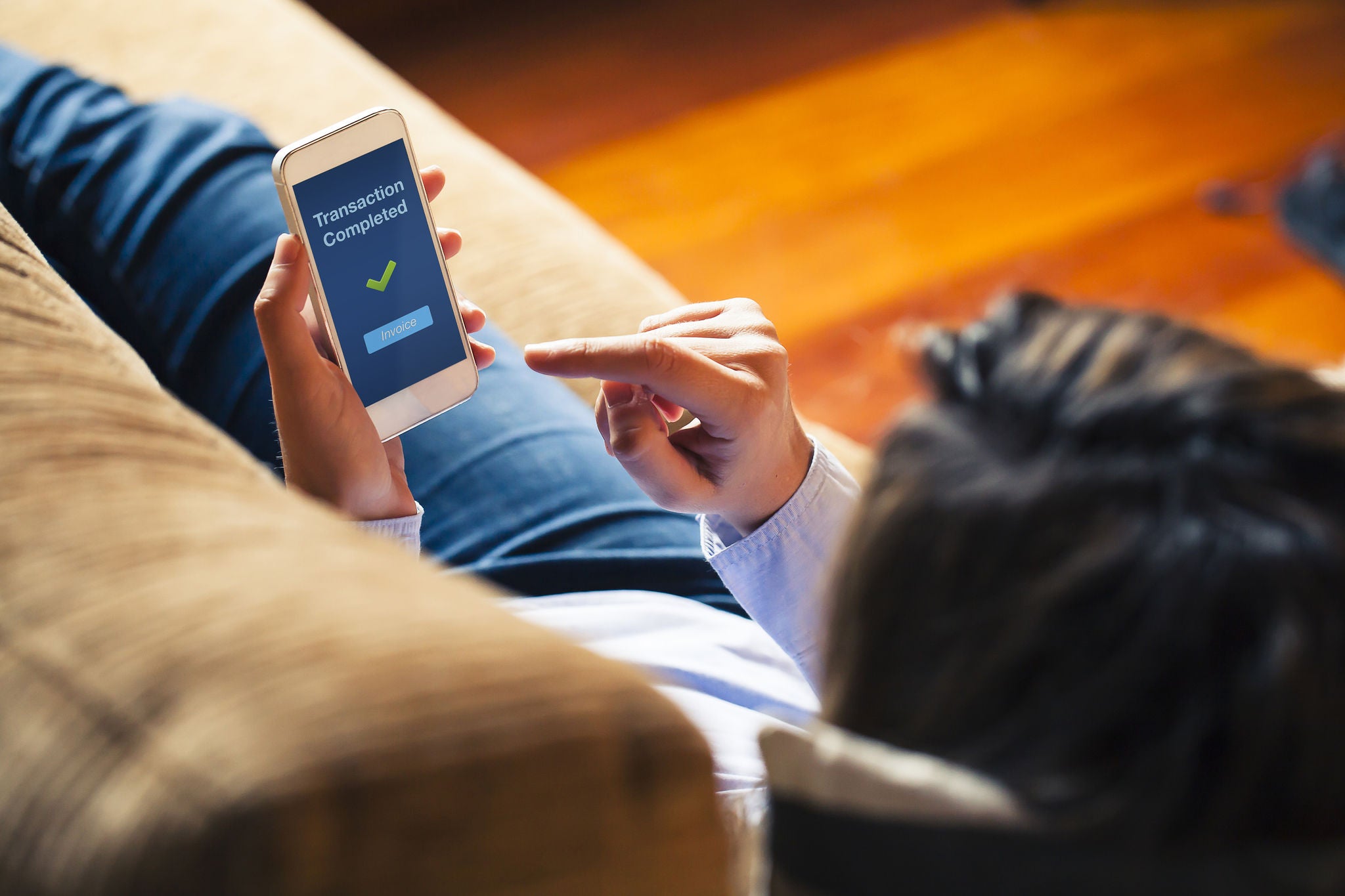 Woman using on line banking on mobile phone at home