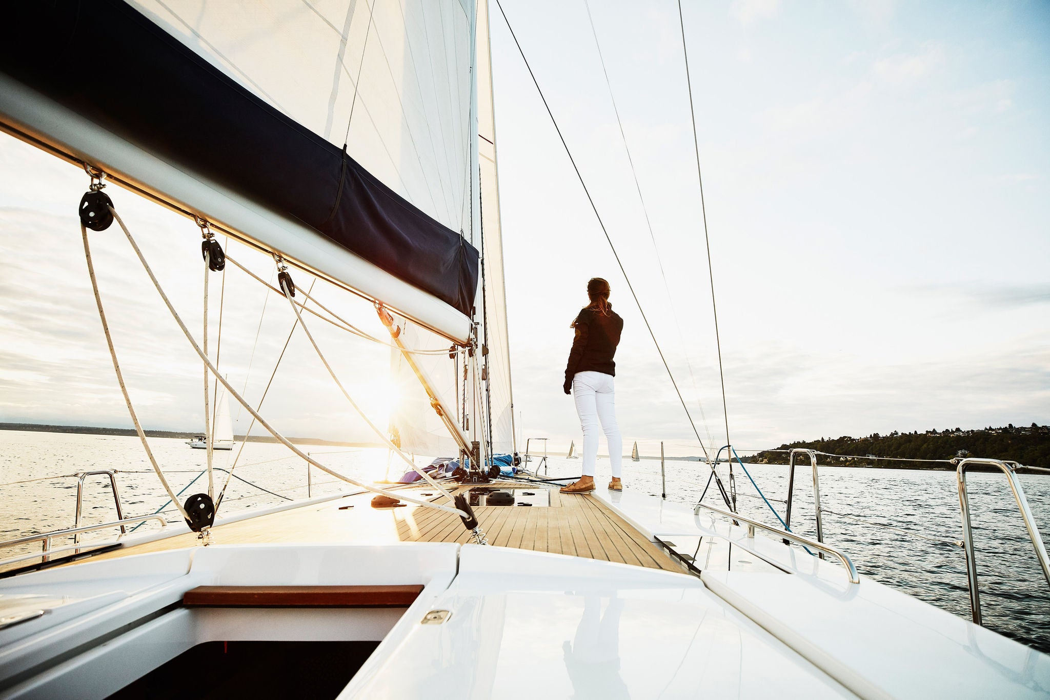 vrouw staat op het voordek van een zeilboot