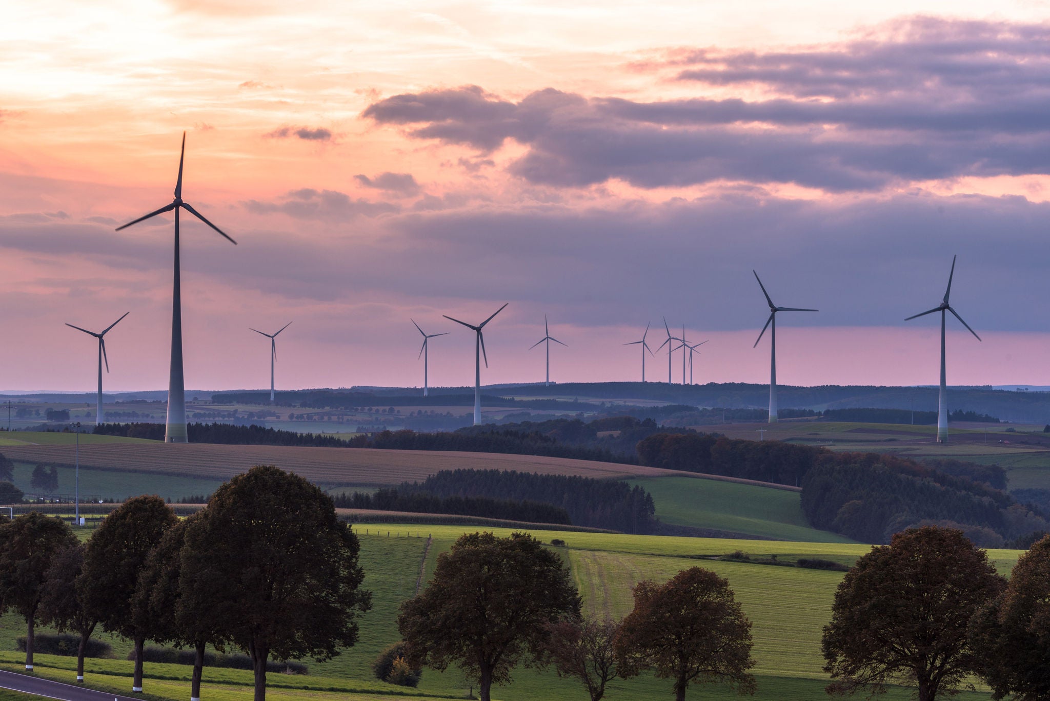 Wind turbines and beautiful sunset sky. Hope for new generations. Representing clean energy as the power source of the future. Struggle against global warming. Hosingen, Oesling in Luxembourg.