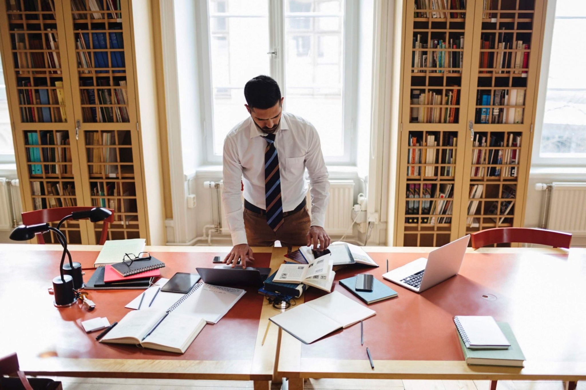 Homme debout travaillant derrière son bureau