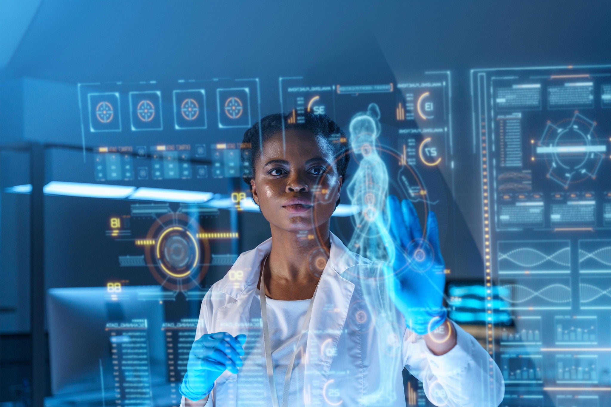 A young African - American doctor works on HUD or graphic display in front of her