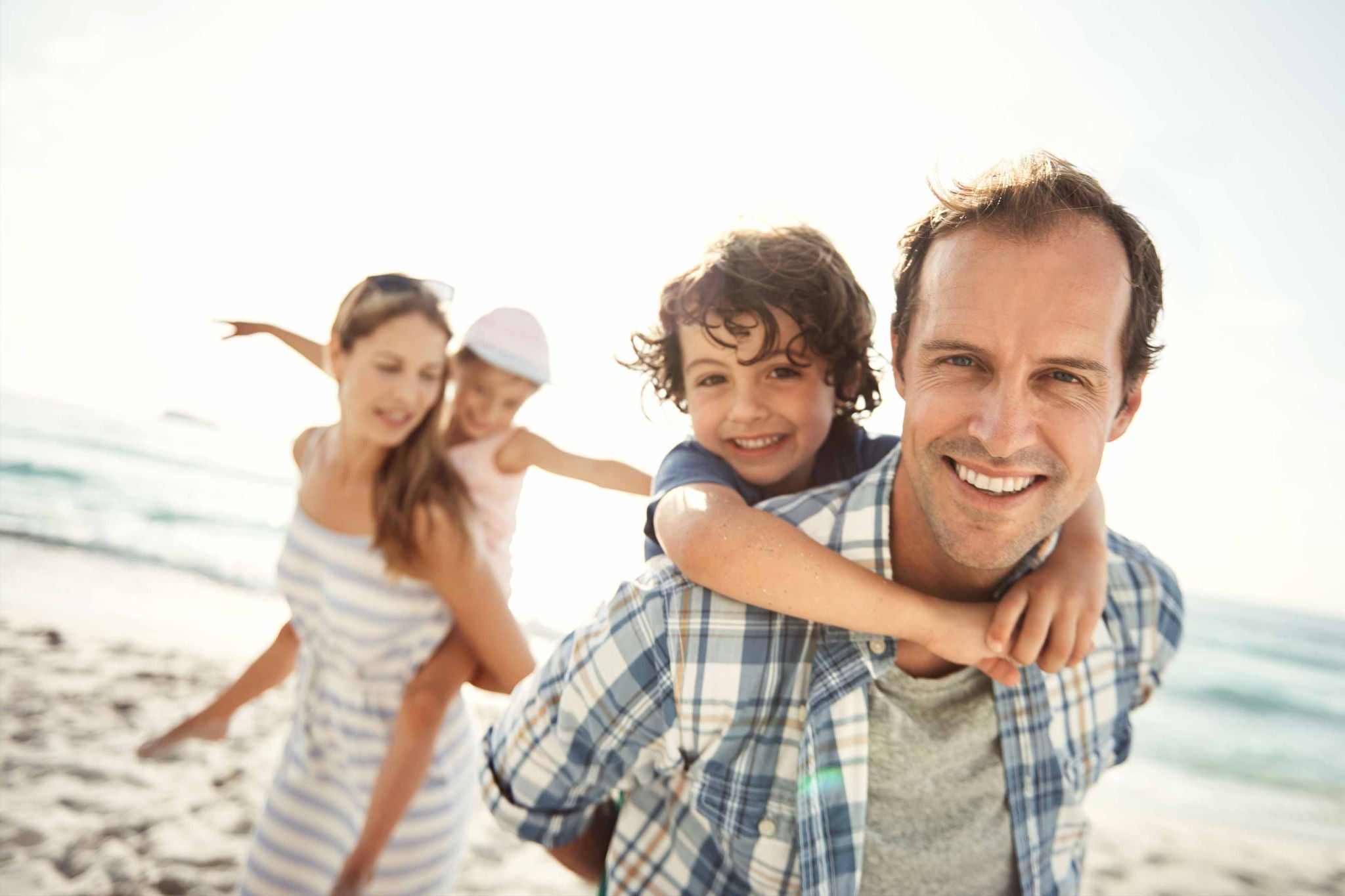 A family of a parent and two kids enjoying vacation at beach