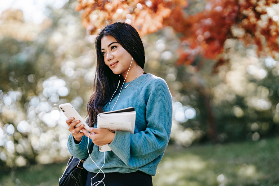 woman listening to music holding book