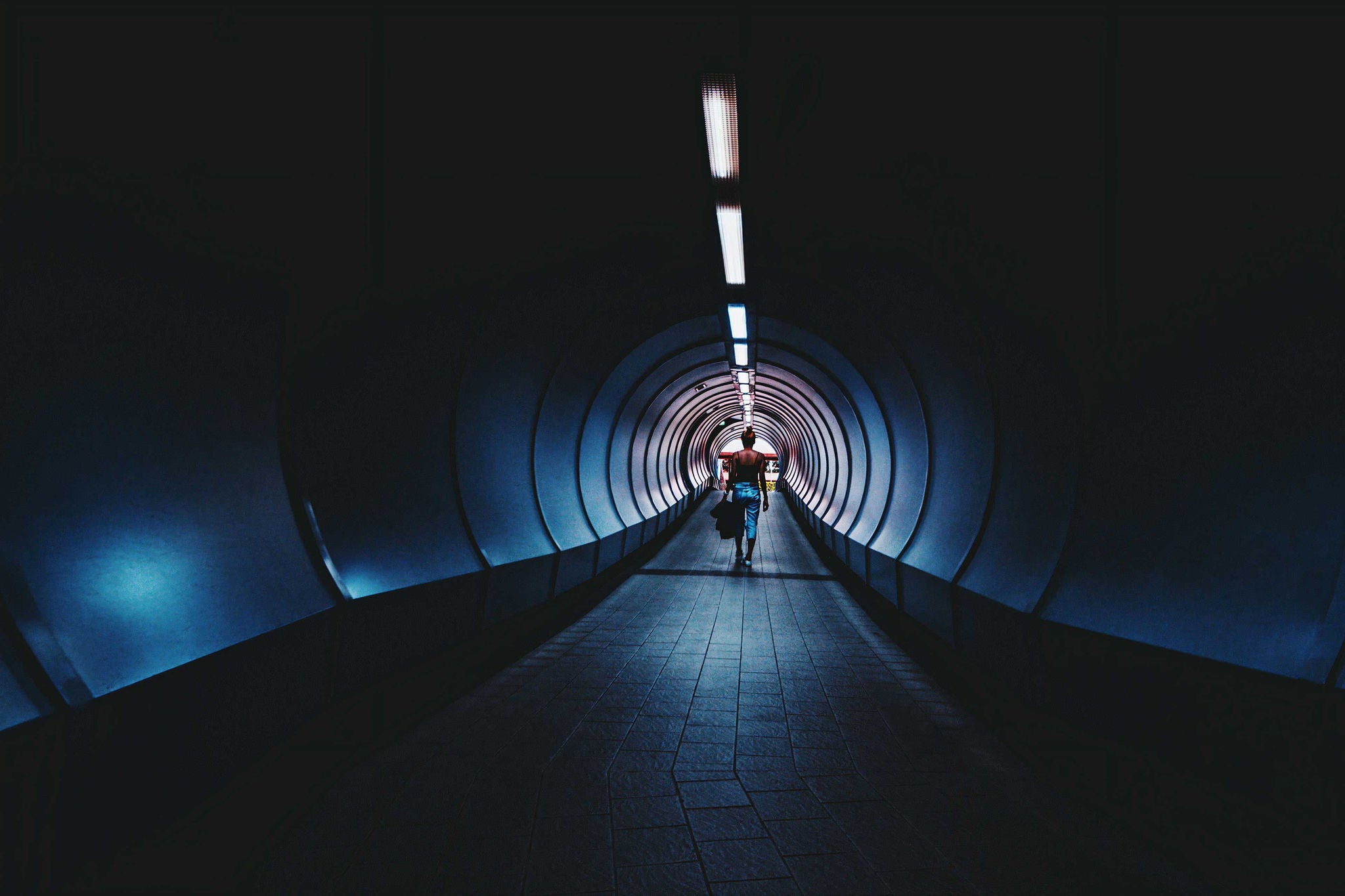 woman walking throught a lit tunnel