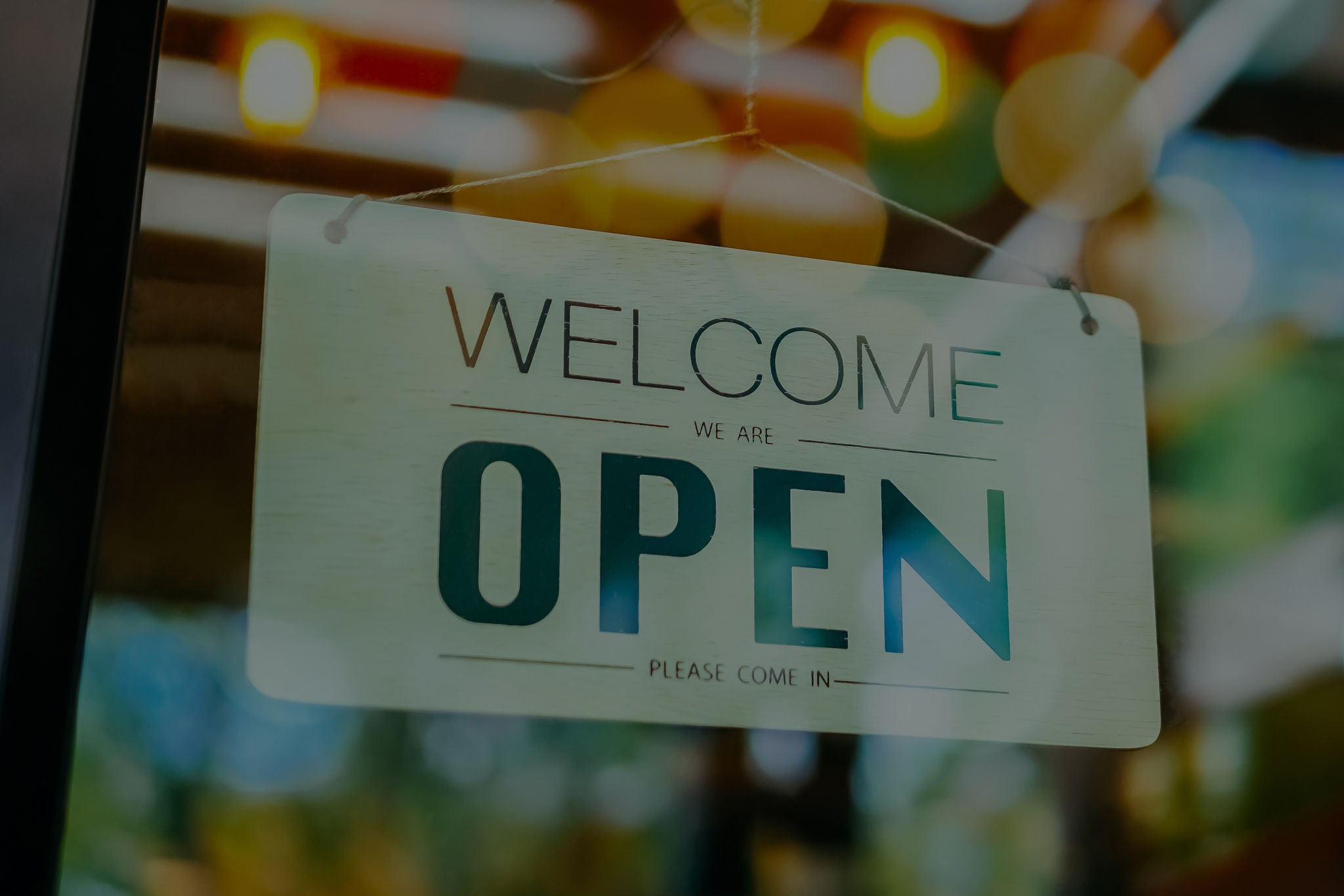 A business sign that says ‘Open’ on cafe or restaurant hang on door at entrance. Vintage color tone style.