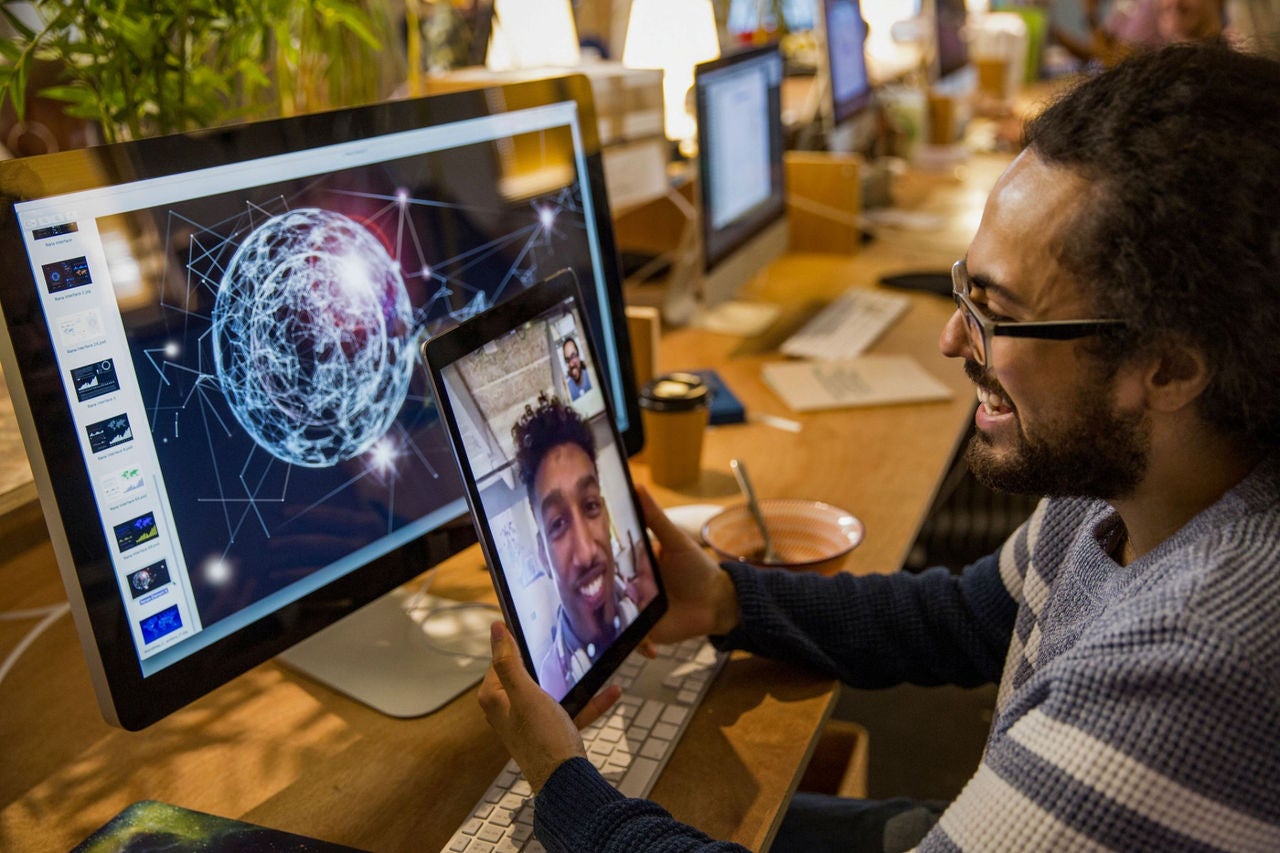 Person sitting in front of computer and talking virtually