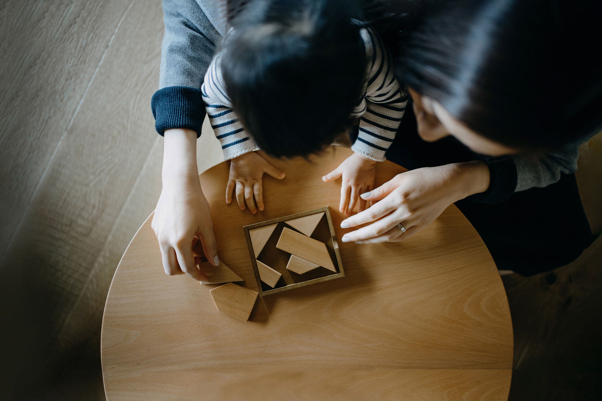 Mother and daughter playing puzzle in living room at home