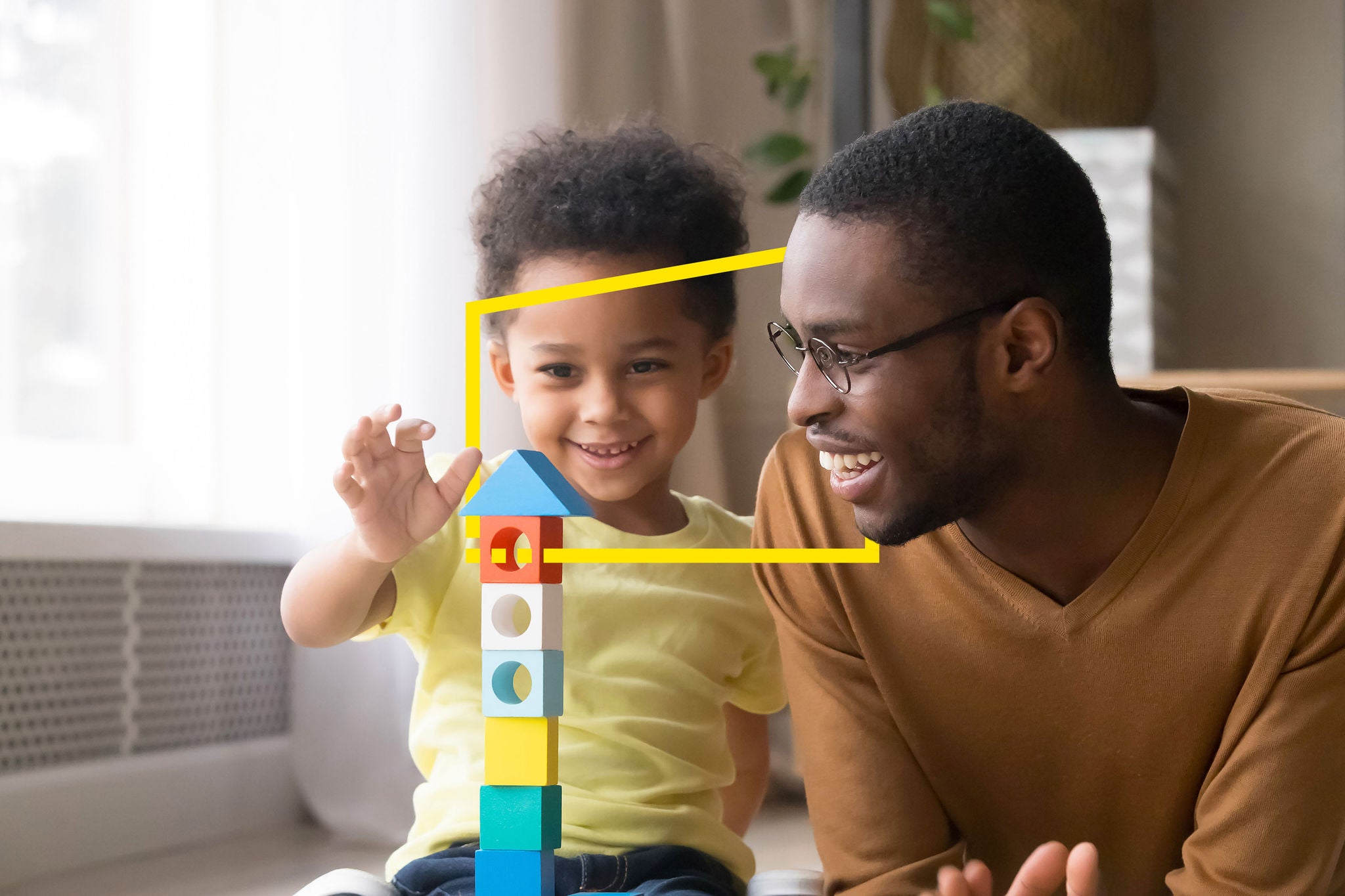 Son playing with dad using wooden blocks