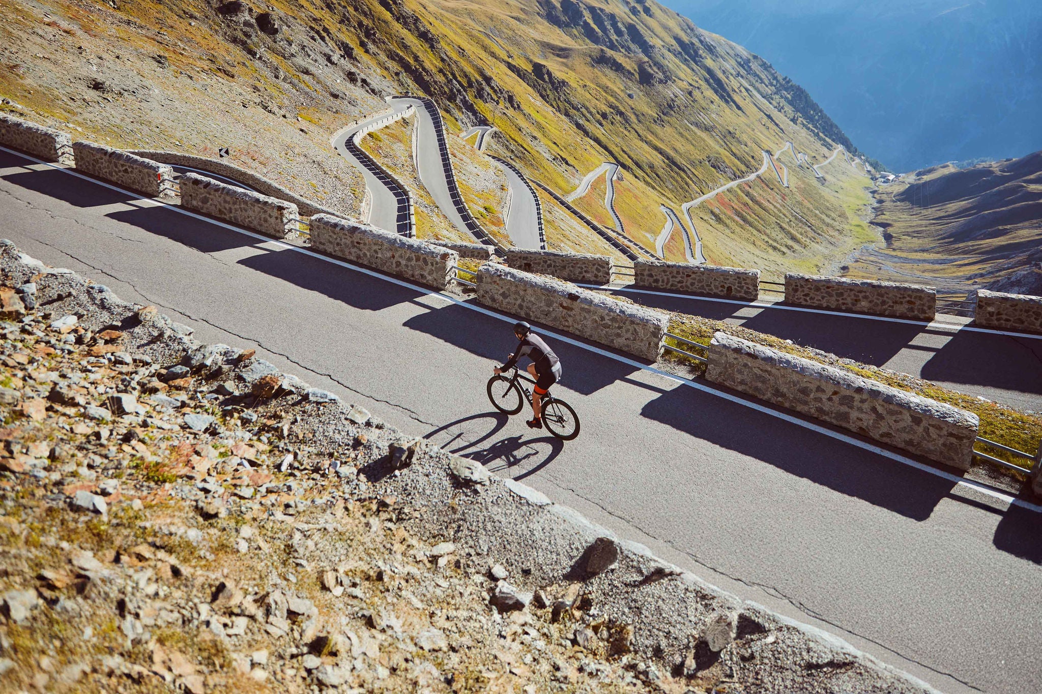 Road Cyclist climbing Passo Dello Stelvio in Italian Alps.