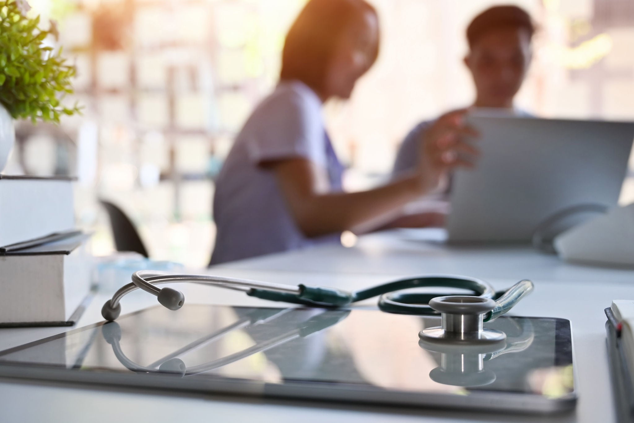 Doctor and patient consult in blur background and medical equipment on hospital workspace.