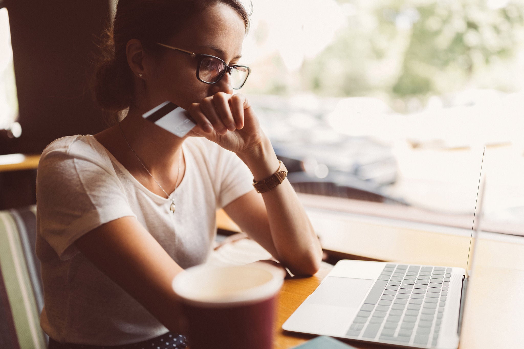 Woman in a cafe having problems with her credit card  