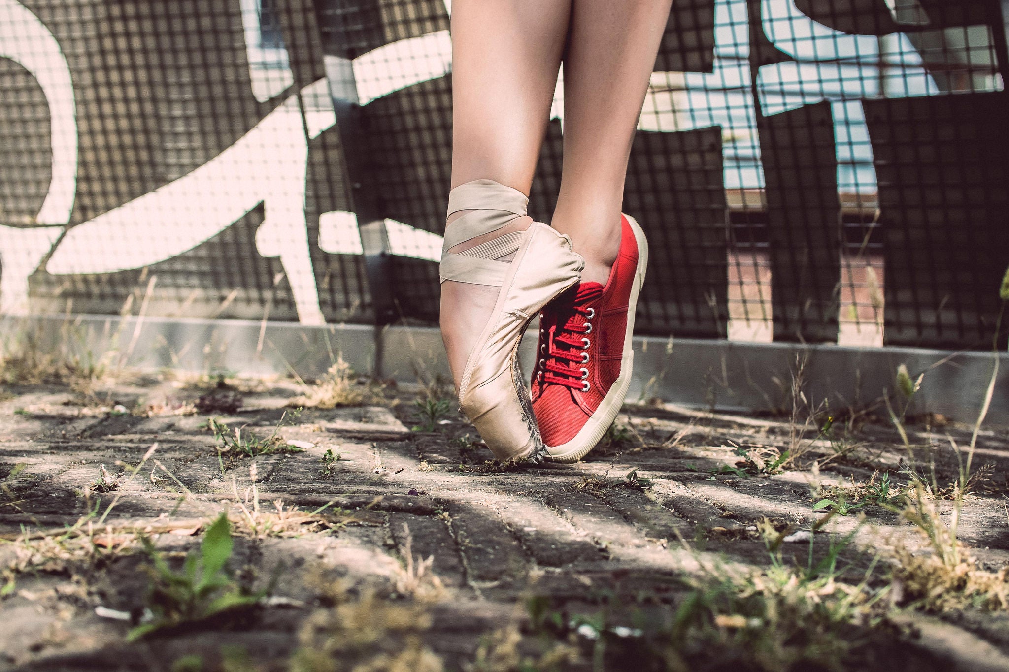 Woman wearing a ballet slipper and tennis shoe