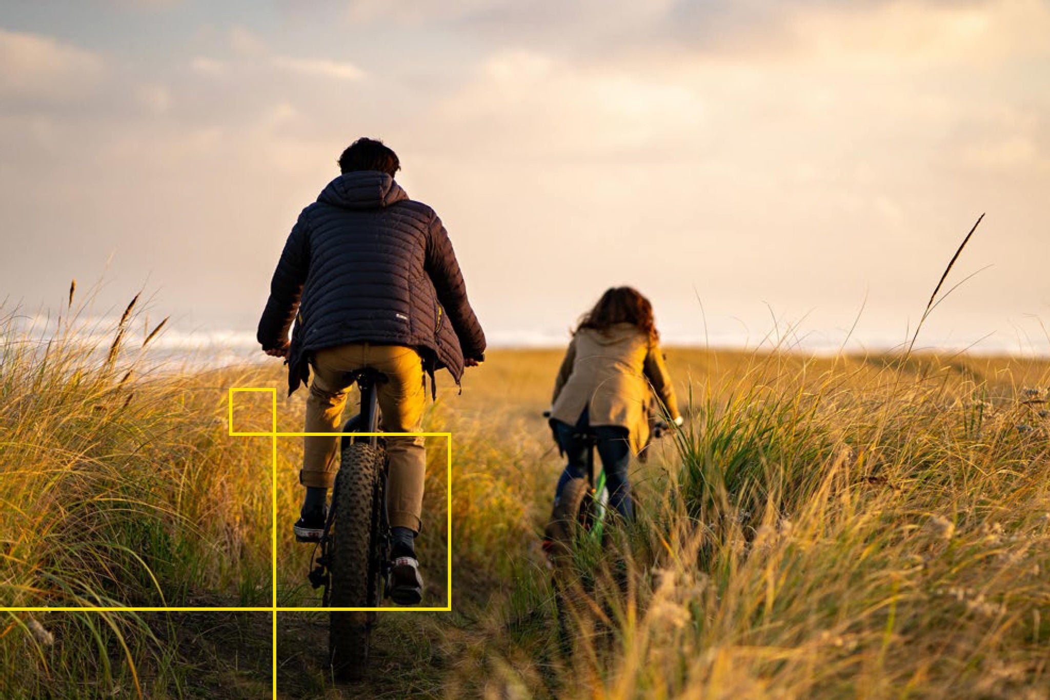 EY - Father and daughter riding bikes along coast