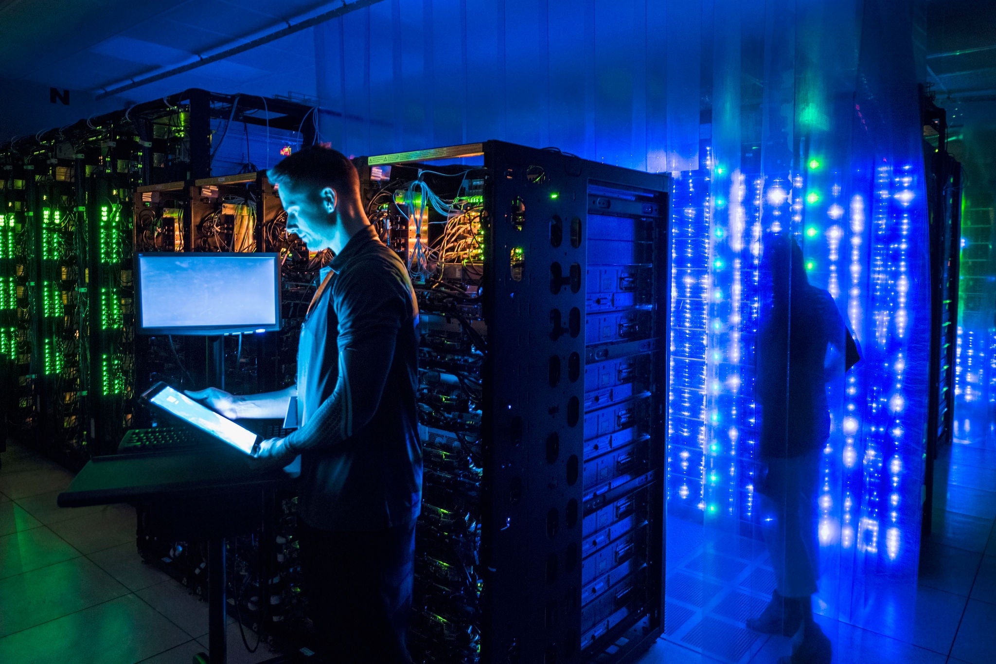 Man using digital tablet in server room