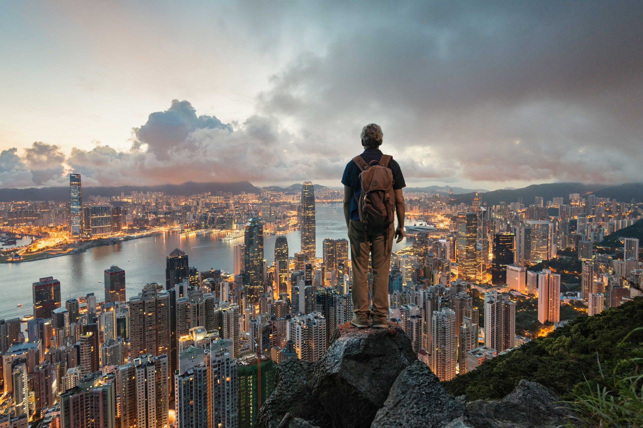 Hombre mirando la ciudad desde una colina