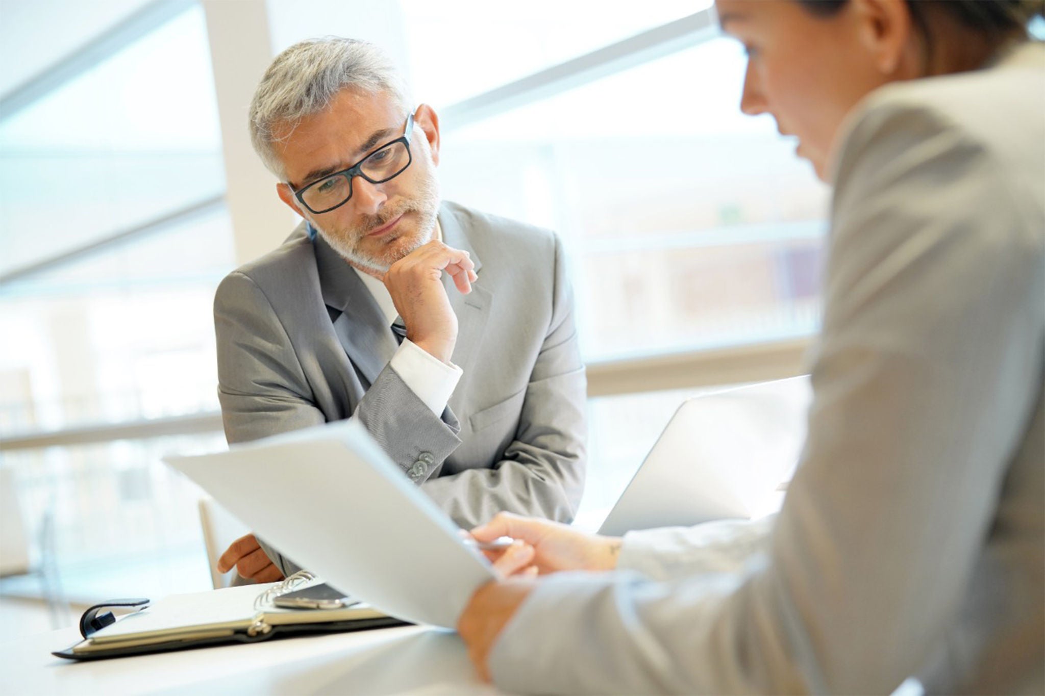 Two colleagues are discussing data with the document data