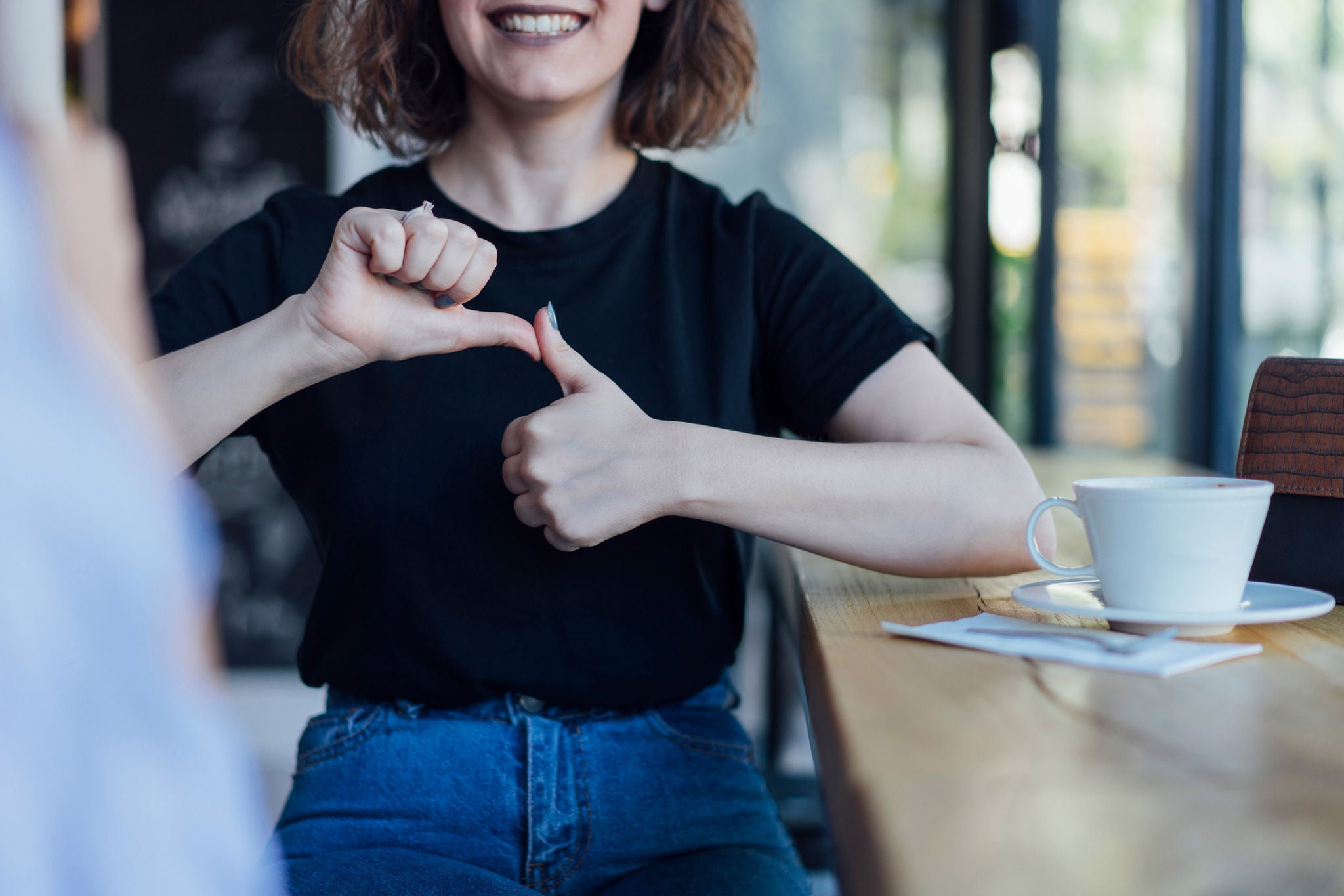 Two young woman speak in sign language