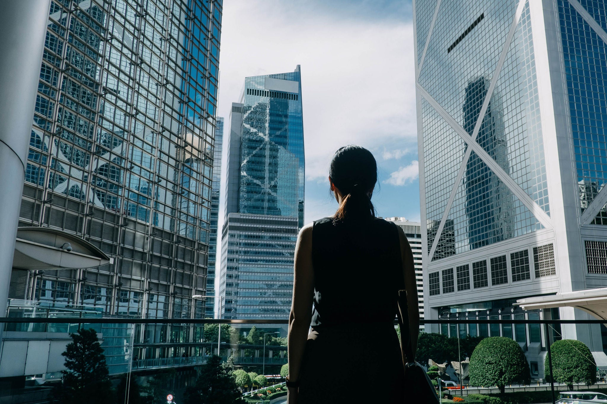 Mujer de espaldas mirando edificios modernos en una terraza